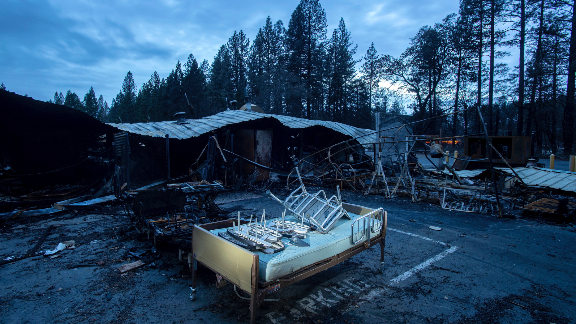 A bed rests outside Cypress Meadows Post-Acute, a nursing home leveled by the Camp Fire, on Tuesday, Dec. 4, 2018, in Paradise, Calif. (AP Photo/Noah Berger)