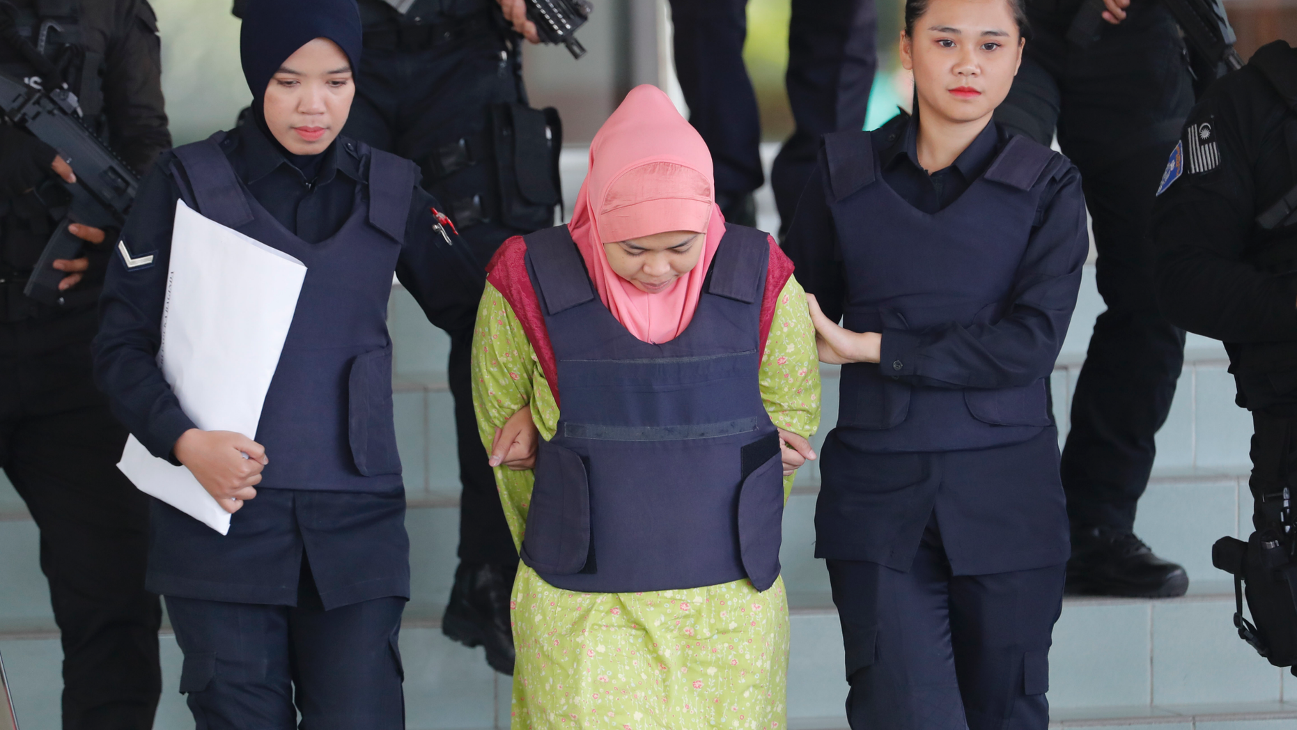 Indonesian Siti Aisyah, center, escorted by police, leaves Shah Alam High Court after a court hearing in Shah Alam, Malaysia on Tuesday, Dec. 18, 2018. Siti and Vietnamese Doan Thi Huong, charged with murdering North Korea leader's half brother Kim Jong Nam, were back in Malaysia court for a procedural hearing. (AP Photo/Vincent Thian)