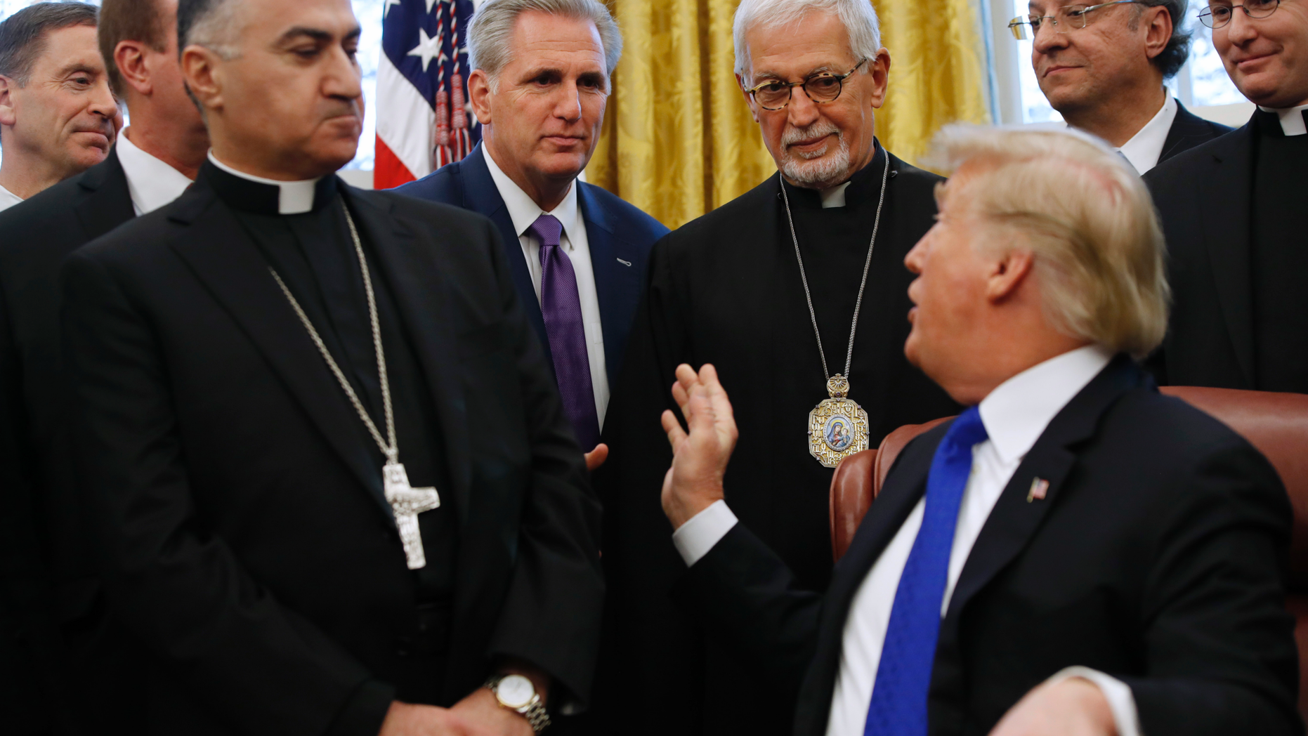 President Donald Trump turns to House Majority Leader Kevin McCarthy, R-Calif., during an event to sign H.R. 390, the "Iraq and Syria Genocide Relief and Accountability Act of 2018," in the Oval Office of the White House, Tuesday, Dec. 11, 2018, in Washington. (AP Photo/Jacquelyn Martin)