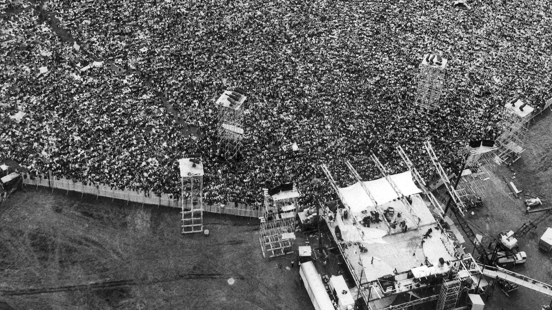 In this Aug. 16, 1969 file aerial photo, music fans pack around the stage at the original Woodstock Music and Arts Festival, lower right, in Bethel, N.Y.