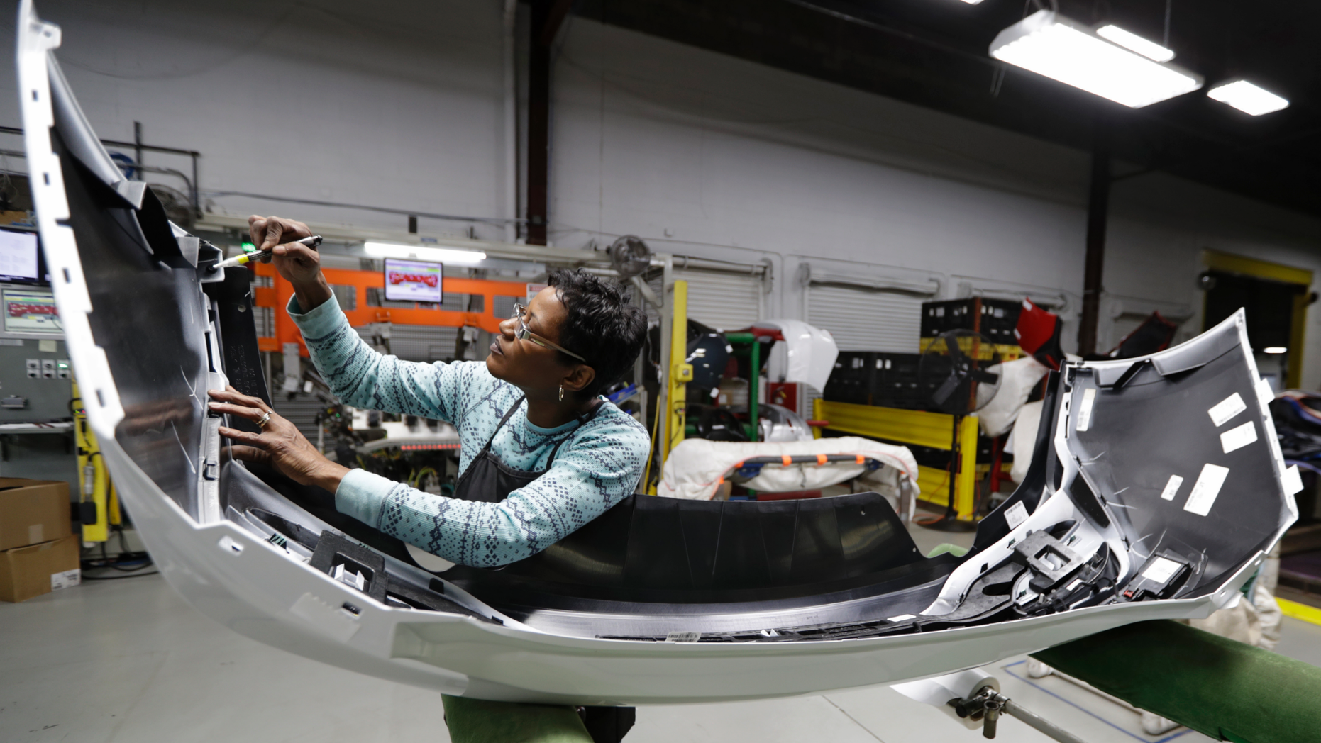FILE- In this Nov. 28, 2018, file photo final inspector Mary Skinner inspects the rear end of a General Motors Chevrolet Cruze at Jamestown Industries in Youngstown, Ohio. On Monday, Dec. 3, the Institute for Supply Management, a trade group of purchasing managers, issues its index of manufacturing activity for November. (AP Photo/Tony Dejak, File)