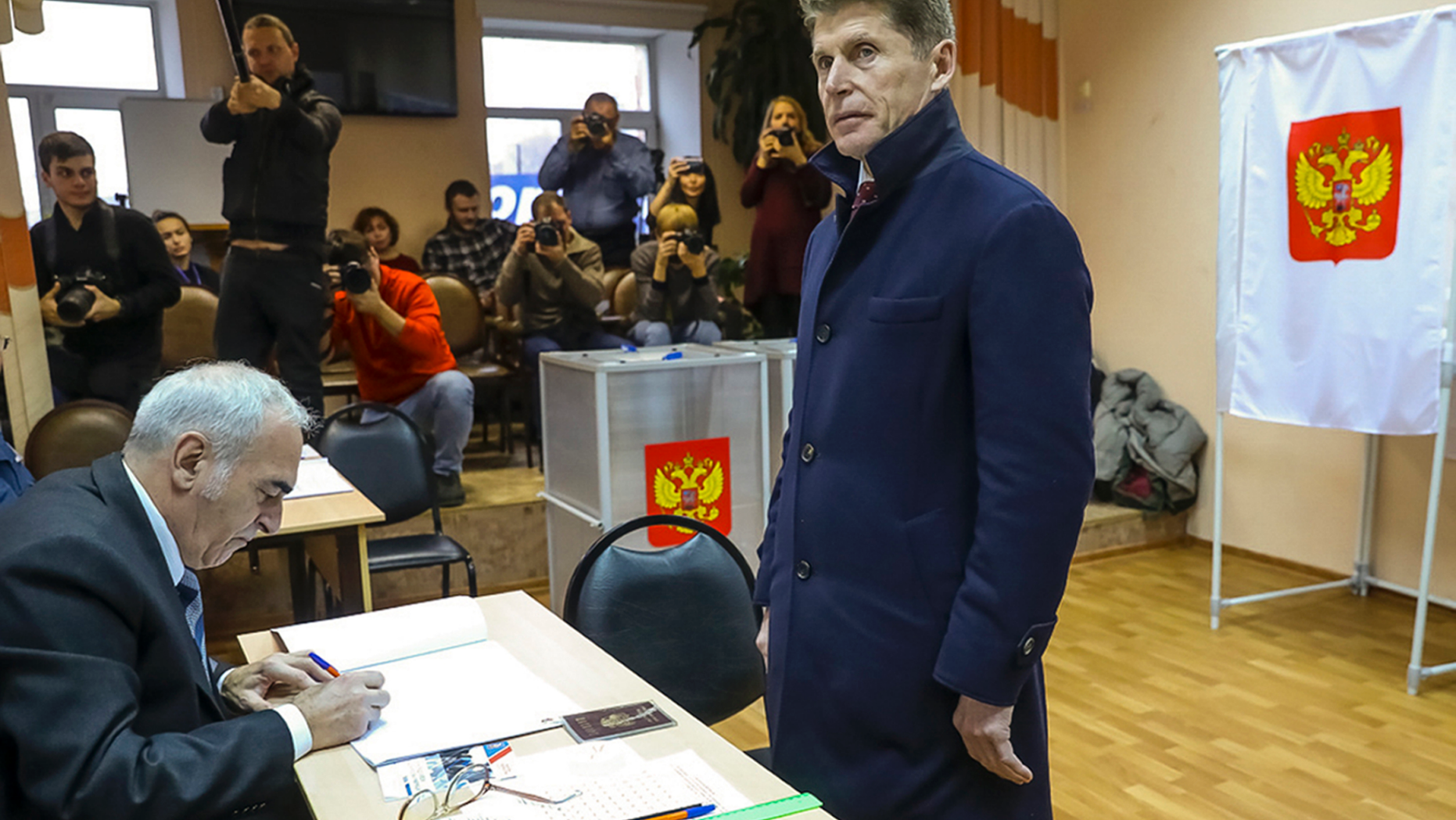 Oleg Kozhemyako, acting governor of the far eastern region of Primorsky Krai stands as he waits to get his ballot at a polling station in Vladivostok, Russia, Sunday, Dec. 16, 2018. Russians living in the far eastern region of Primorsky Krai cast their votes Sunday for a new governor in a tightly watched election, with Kozhemyako reported to be leading the vote. (Igor Novikov, Governor and Administration of Primorye Territory press service via AP)