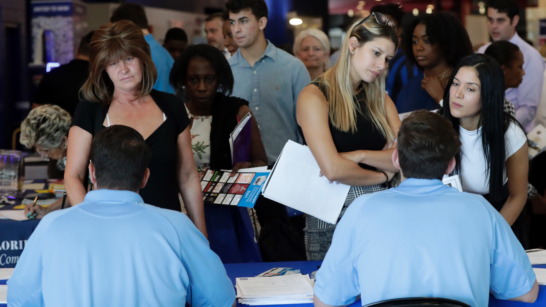 FILE- In this June 21, 2018 file photo, job applicants talks with representatives from Aldi at a job fair hosted by Job News South Florida, in Sunrise, Fla. On Thursday, Dec. 6, payroll processor ADP reports how many jobs private employers added in November. (AP Photo/Lynne Sladky, File)