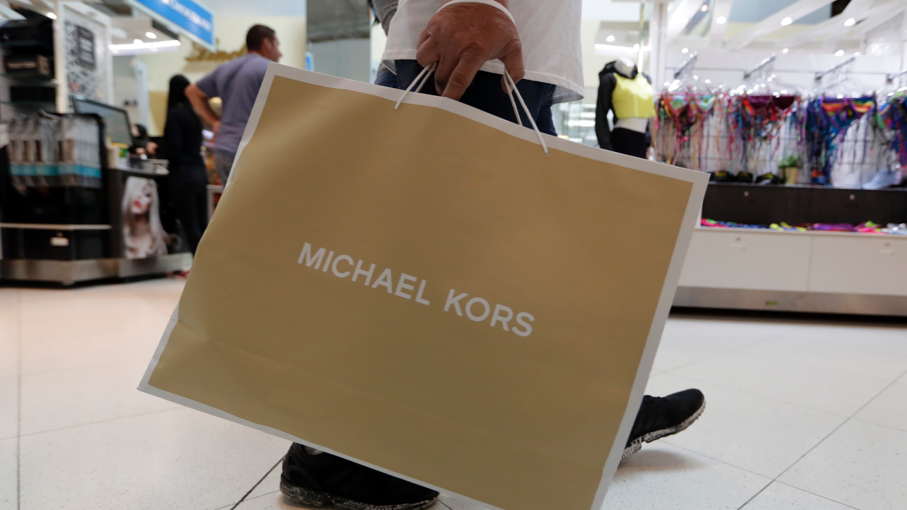 FILE- In this Nov. 23, 2018, file photo a shopper walks through Dolphin Mall while shopping on Black Friday in Miami. On Friday, Dec. 14, the Commerce Department releases U.S. retail sales data for November. (AP Photo/Lynne Sladky, File)