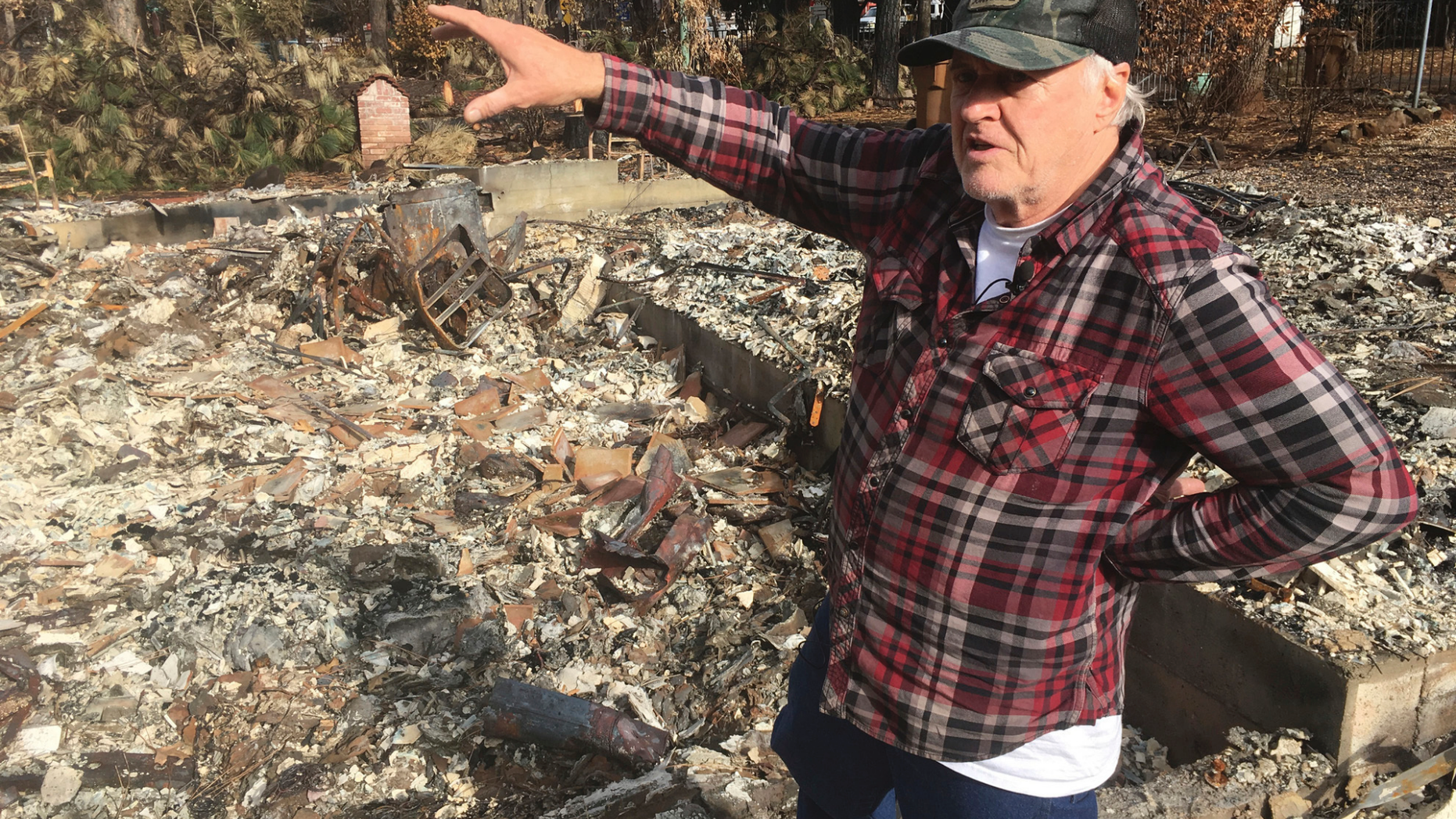Returning resident Frank Windt checks his home that was burned in the Camp Fire in Paradise, Calif., Wednesday, Dec. 5, 2018. Hundreds of residents were finally allowed back into neighborhoods a month after a blaze killed at least 85 people and destroyed about 14,000 homes. More than 50,000 people in Paradise and the neighboring communities of Magalia and Concow were forced to quickly flee the towering, wind-driven flames that charred 240 square miles (622 square kilometers). (AP Photo/Haven Daley)