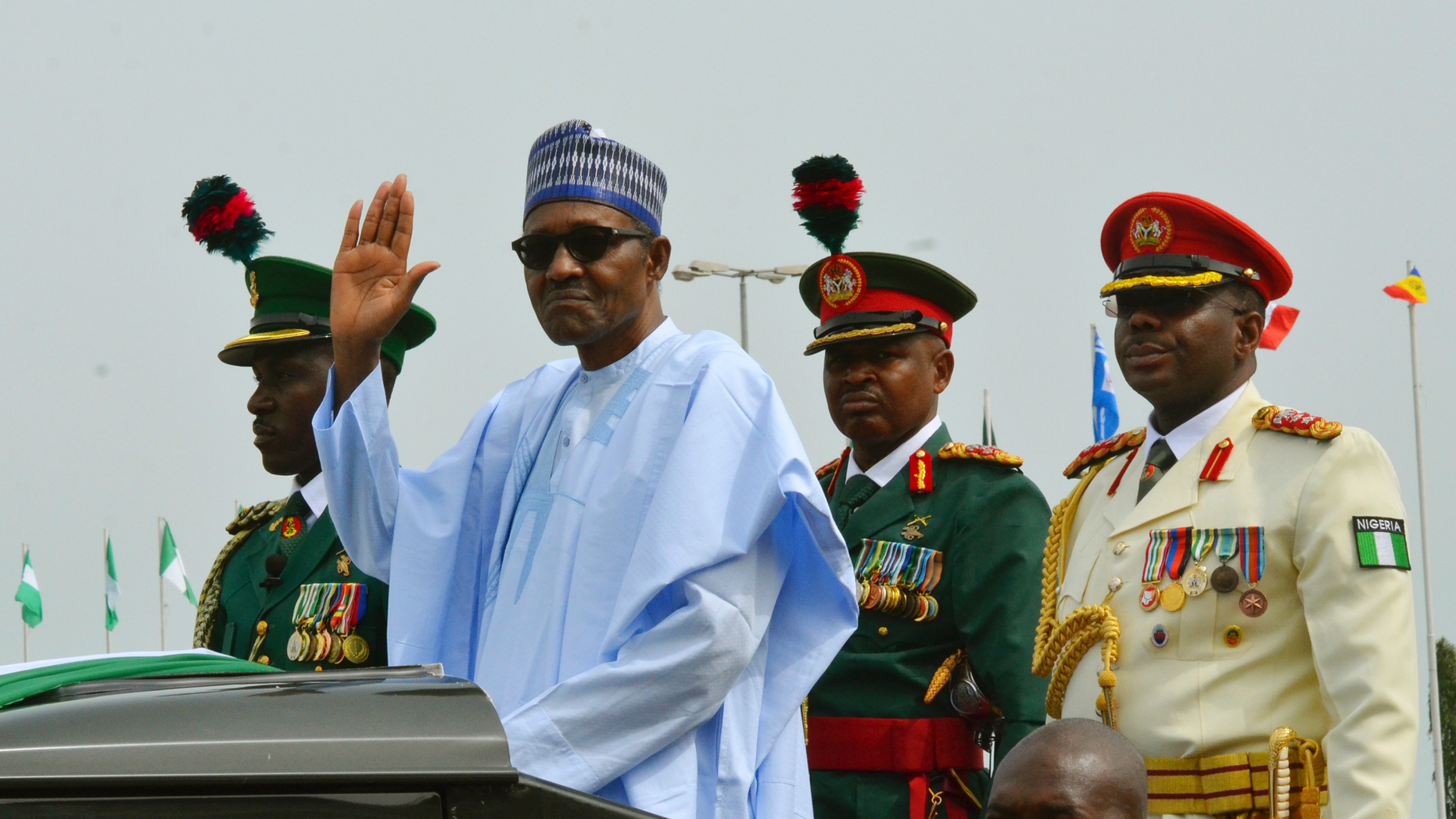 FILE - In this Monday Oct. 1, 2018 file photo, Nigerian President Muhammadu Buhari waves to the crowd during the 58th anniversary celebrations of Nigerian independence, in Abuja, Nigeria. Nigeria's president on Sunday Dec. 2, 2018, took the extraordinary step of denying rumors that he died and was replaced by a body double, telling the country that he is alive and well. (AP Photo/Olamikan Gbemiga, File)