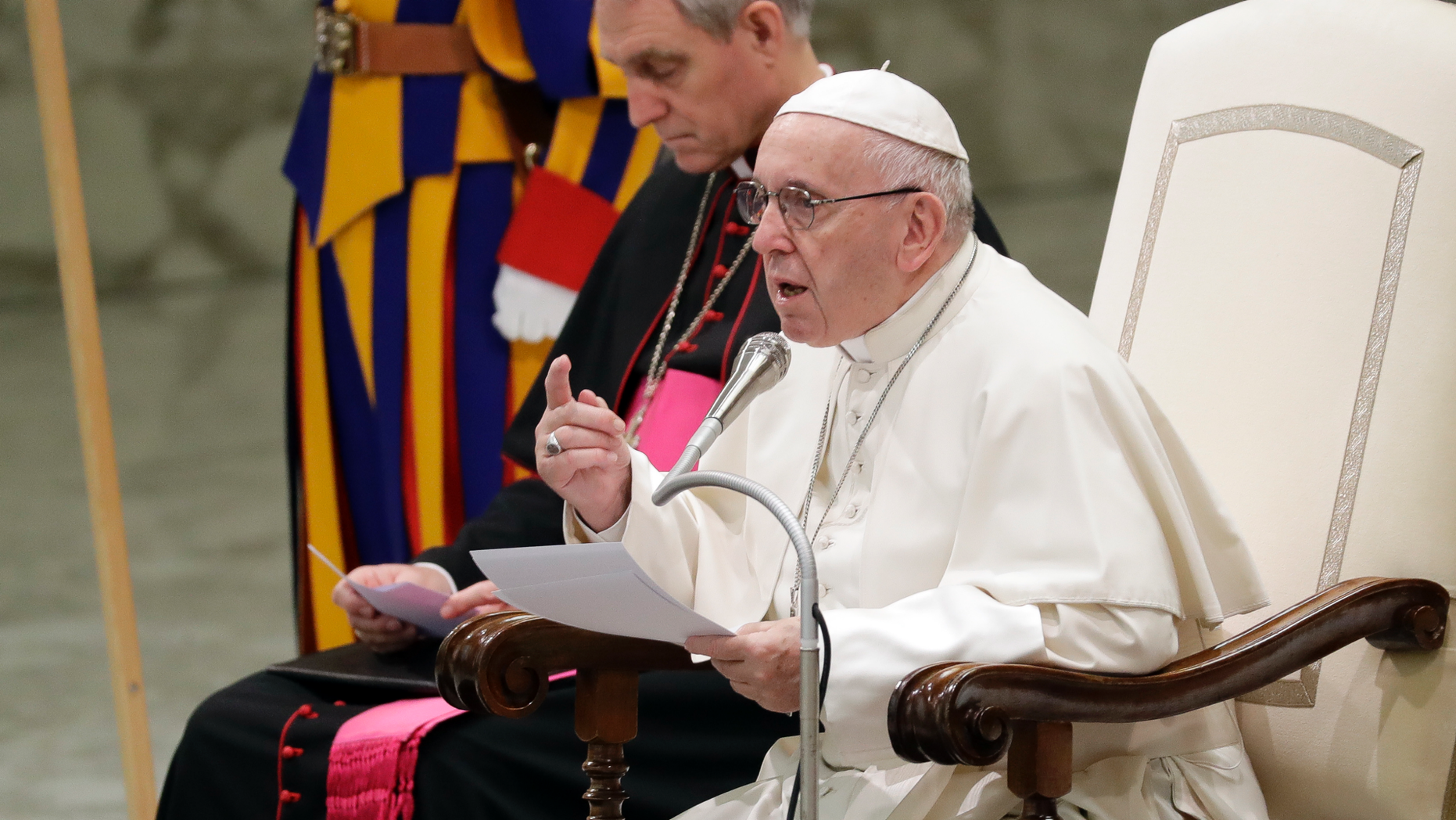 Pope Francis, flanked by Vatican Prefect of a Pontifical Household, Archbishop Georg Ganswein, delivers his summary during a weekly ubiquitous audience, in a Pope Paul VI hall, during a Vatican, Wednesday, Dec. 5, 2018. (AP Photo/Andrew Medichini)