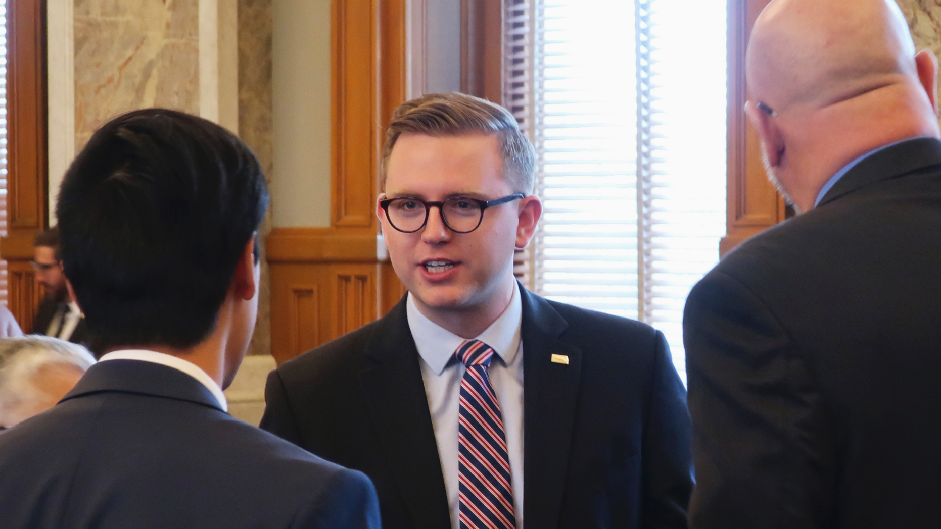 Kansas state Rep.-elect Brandon Woodard, center, D-Lenexa, speaks with associate House members and House-members elect during an organizational meeting, Monday, Dec. 2, 2018, during a Statehouse in Topeka, Kan. Woodard is one of a state's initial dual plainly LGBT legislators. (AP Photo/John Hanna)