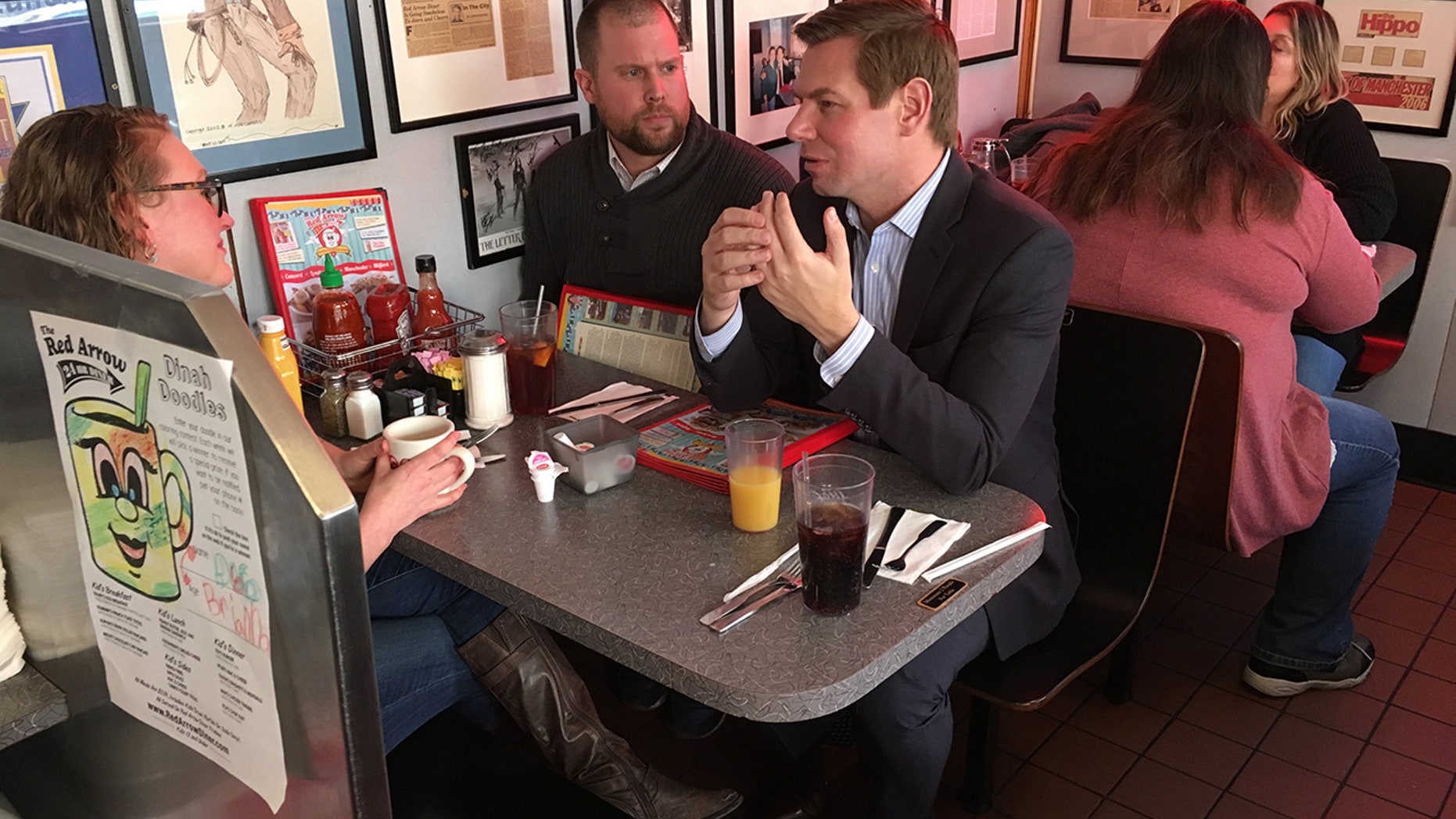 Congressman Eric Swalwell speaks with two New Hampshire Democratic state representatives at the Red Arrow Diner in Manchester.
