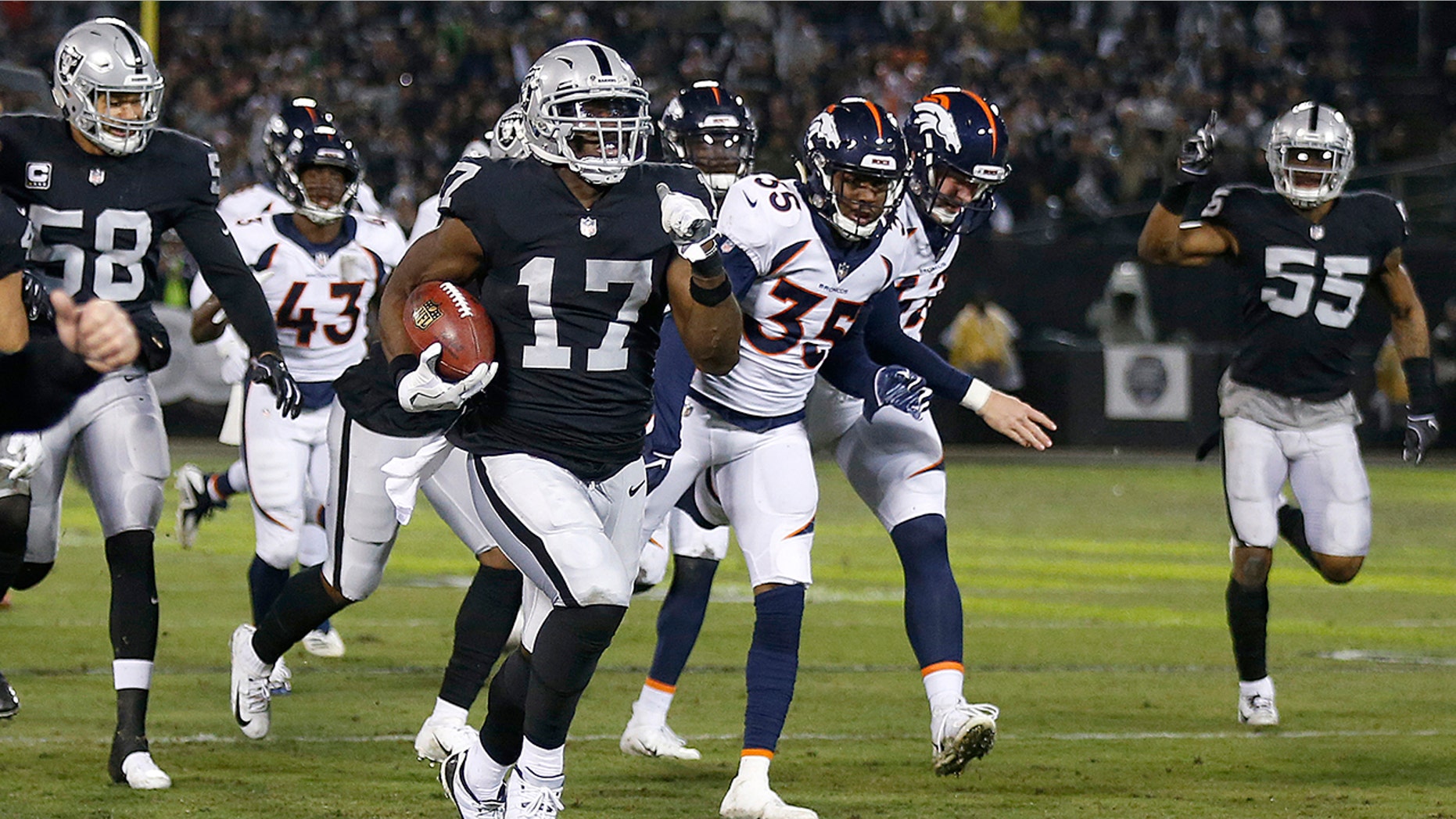 Oakland Raiders' Dwayne Harris (17) returns a punt for a touchdown against the Denver Broncos during the first half of an NFL football game in Oakland, Calif., Monday, Dec. 24, 2018.