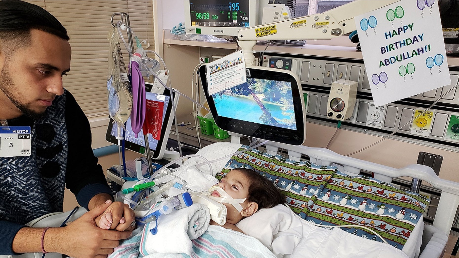 Ali Hassan, 22, sits with his son Abdullah, 2, who is on life support at UCSF Benioff Children's Hospital in Oakland, Calif.