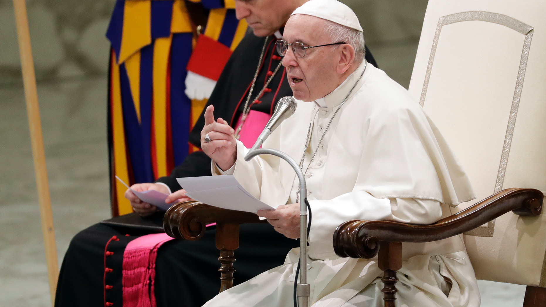 Pope Francis, flanked by Vatican Prefect of the Pontifical Household, Archbishop Georg Ganswein, delivers his message during a weekly general audience, in the Pope Paul VI hall, at the Vatican, Wednesday, Dec. 5, 2018. (AP Photo/Andrew Medichini)