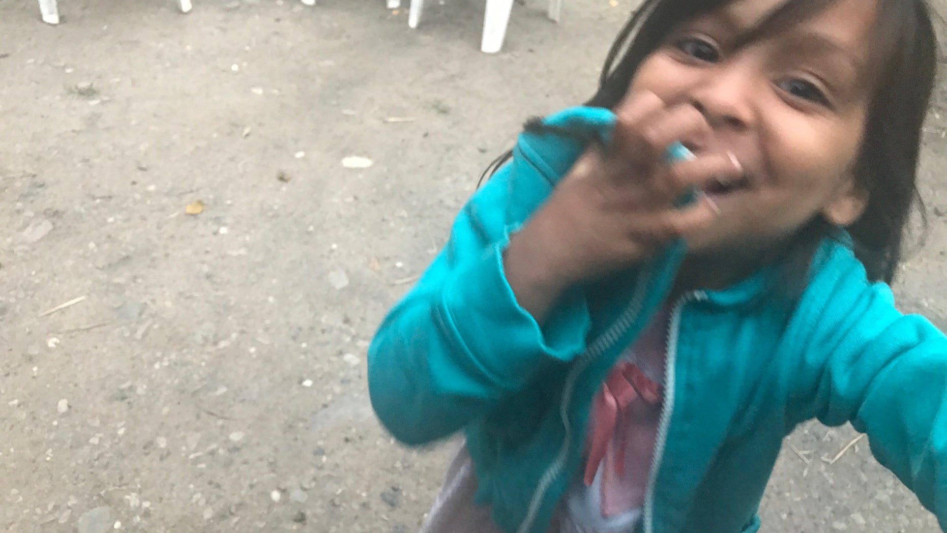 A Venezuelan migrant making the journey through Colombian plays with the only toy she has: her mother's identification card.<br>