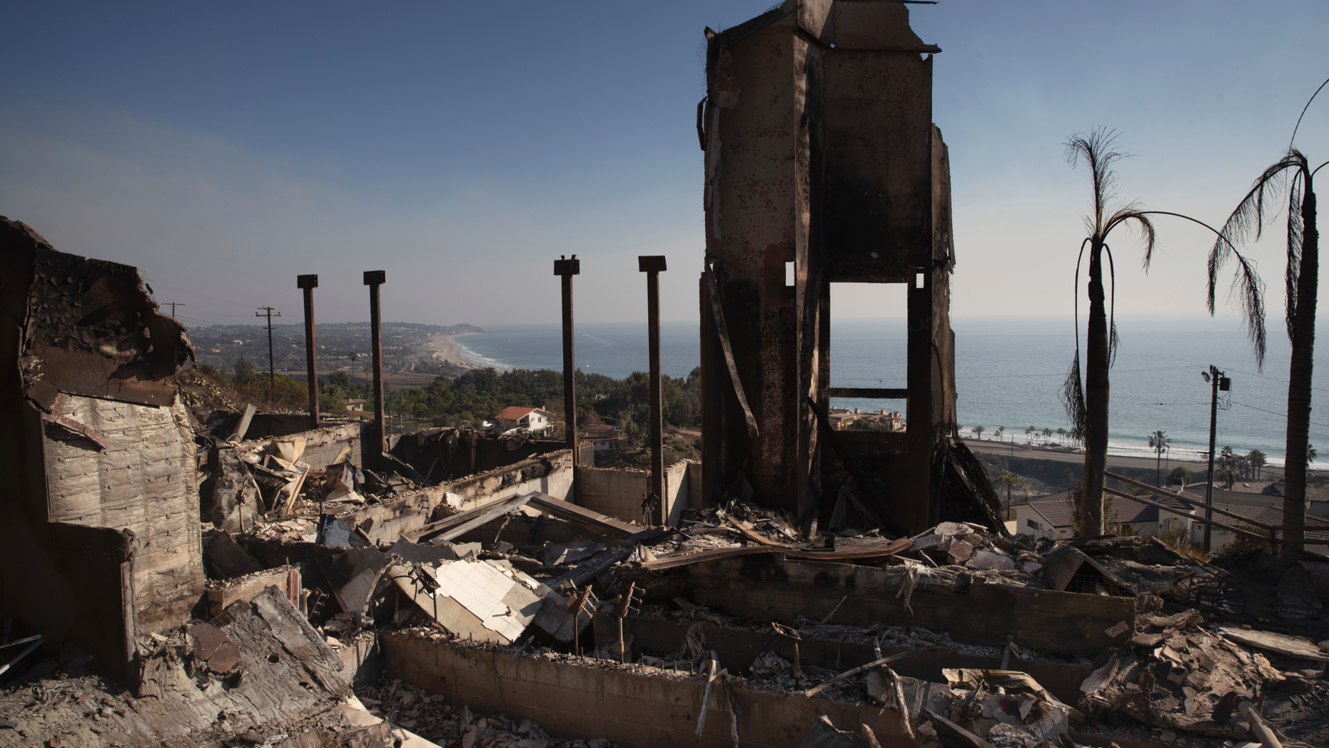 FILE - In this Nov. 11, 2018 file photo, a home burned down by a wildfire sits on a hilltop overlooking the Pacific Ocean in Malibu, Calif. Authorities estimate it will cost at least $3 billion to clear debris of 19,000 homes destroyed by California wildfires last month. State and federal disaster relief officials said Tuesday, Jan. 11, that private contractors will most likely begin removing debris in January from Butte, Ventura and Los Angeles counties and costs are likely to surpass initial estimates. (AP Photo/Jae C. Hong, File)