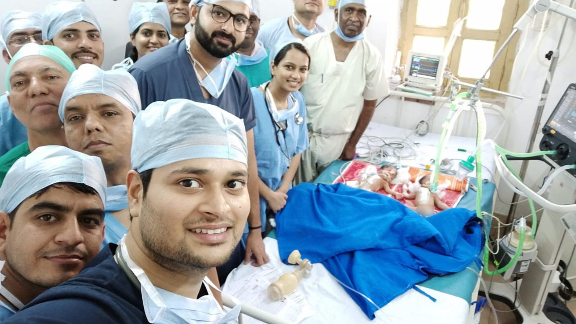 The team of gifted surgeons, pictured moments after successfully separating the twins, performed the lifesaving operation free of charge.