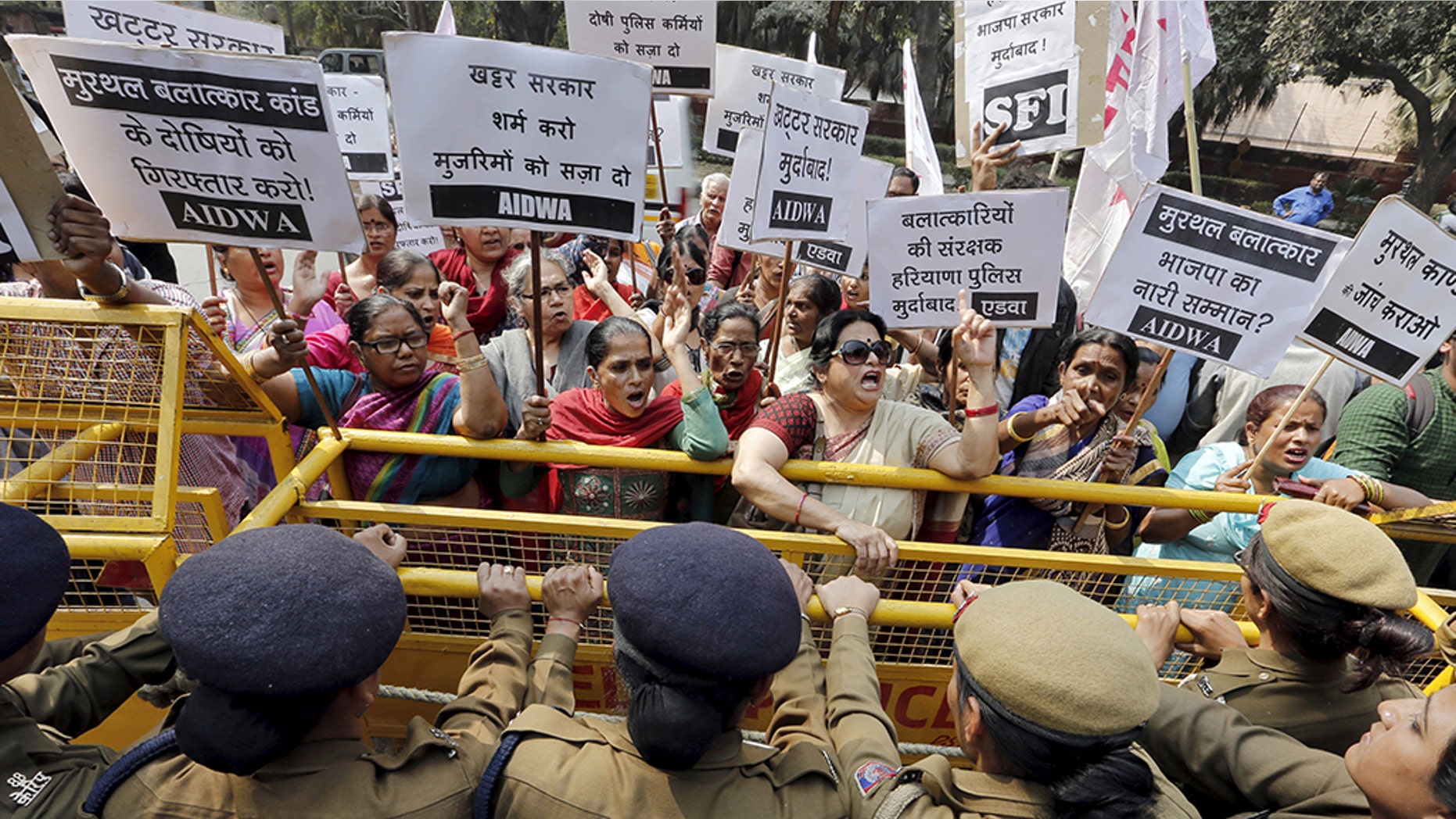 Activists from All India Democratic Women's Association shout slogans behind a police barricade outside the Haryana Bhawan during a protest in New Delhi, India. (Reuters)