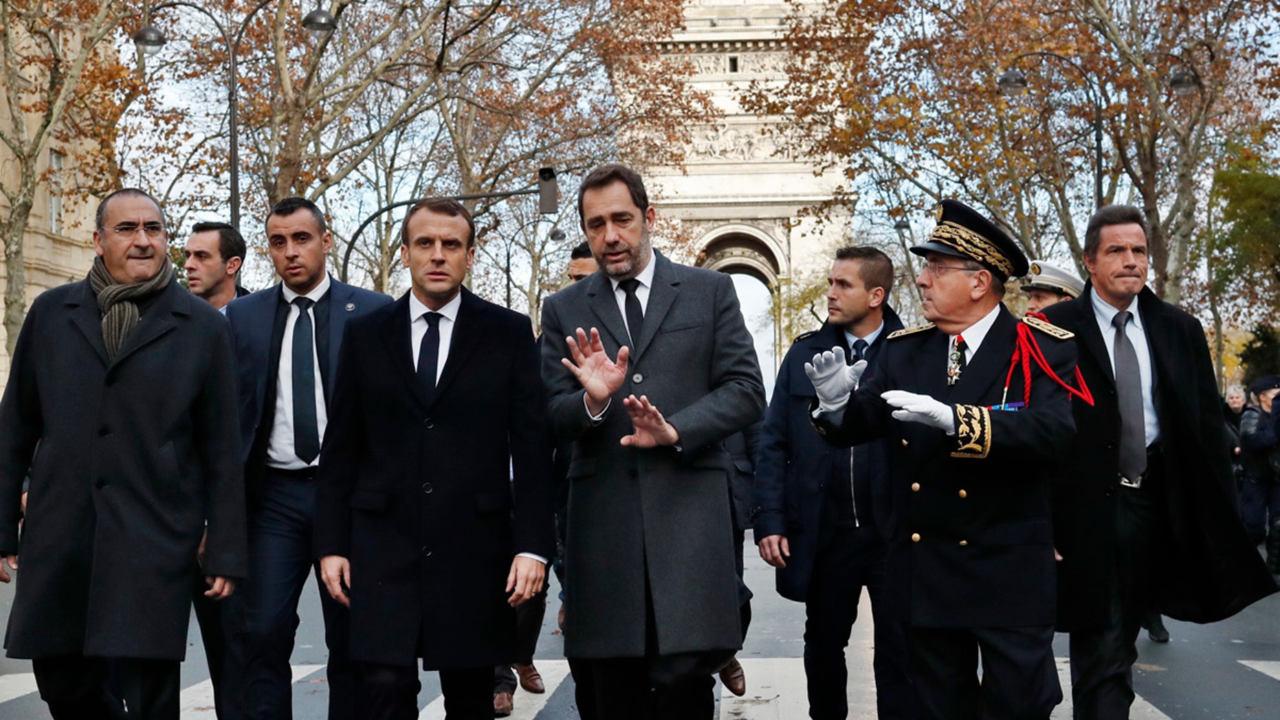 France's President Emmanuel Macron, centre left, France's Interior Minister Christophe Castaner, center, Secretary of State to a Interior Minister Laurent Nunez, left, and Paris military Prefect Michel Delpuech, right, arrive to revisit firefighters and proof military officers a day after a demonstration, in Paris, Sunday, Dec. 2, 2018. (AP Photo/Thibault Camus)