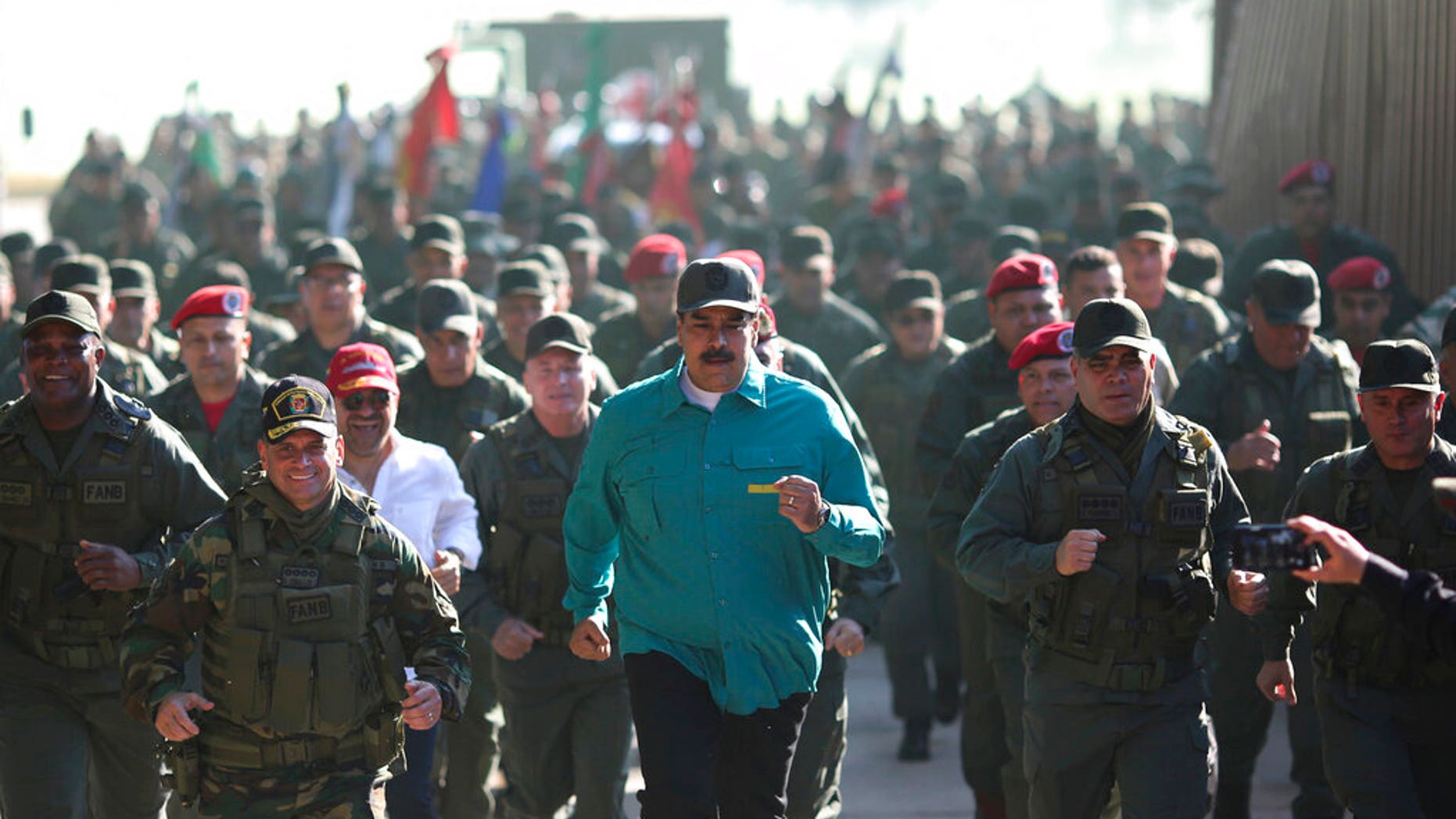 In this photo released to the media by the Miraflores presidential palace press office, Venezuelan President Nicolas Maduro jogs ahead of soldiers during a visit last month to Carabobo State. (Marcelo Garcia/Miraflores presidential palace press office via AP)