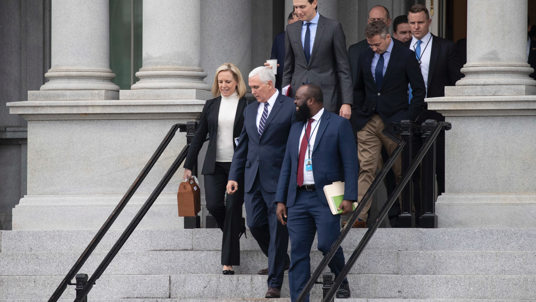 Homeland Security Secretary Kirstjen Nielsen, left, Vice President Mike Pence, White House legislative affairs aide Ja'Ron Smith, followed by White House Senior Adviser Jared Kushner, and others, walk down the steps of the Eisenhower Executive Office building, on the White House complex, after a meeting with staff members of House and Senate leadership, Saturday, Jan. 5, 2019, in Washington. (AP Photo/Alex Brandon)