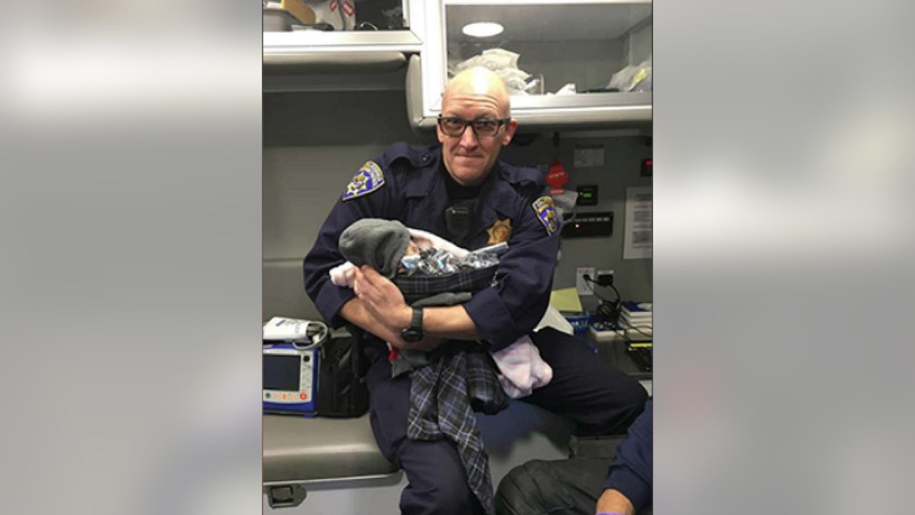 California Highway Patrol Officer Jeffrey Lloyd holds a baby he helped deliver along Highway 99 on Monday. (CHP South Sacramento)