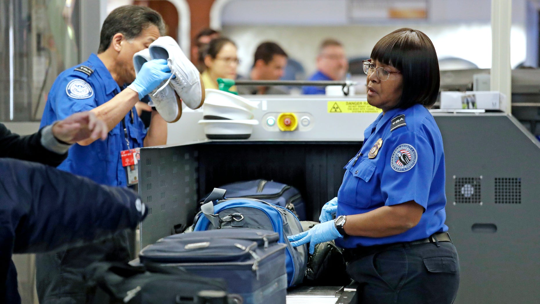 Transportation Security Administration (TSA) officers assist travelers with luggage through a security screening area during a partial federal government shutdown Monday, Dec. 31, 2018, at Seattle-Tacoma International Airport in Washington state. (Associated Press)