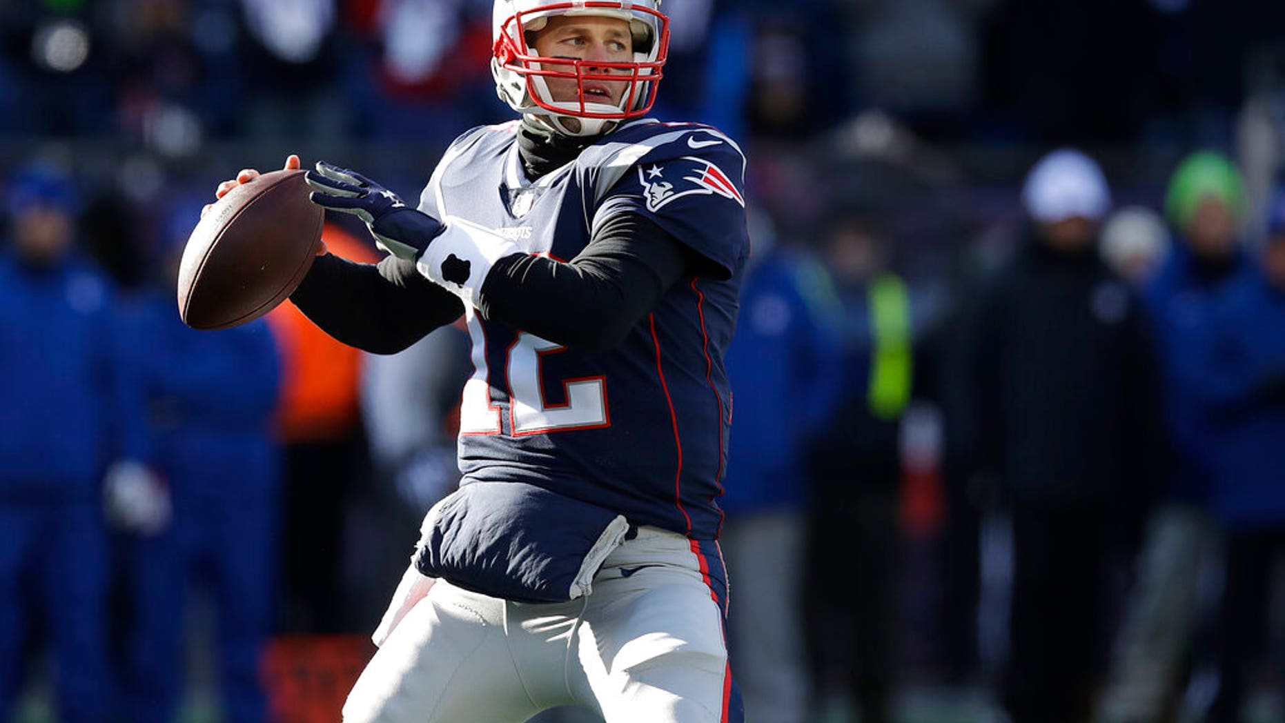 New England Patriots quarterback Tom Brady drops back to pass against the Los Angeles Chargers defensive during the first half of an NFL divisional playoff football game.