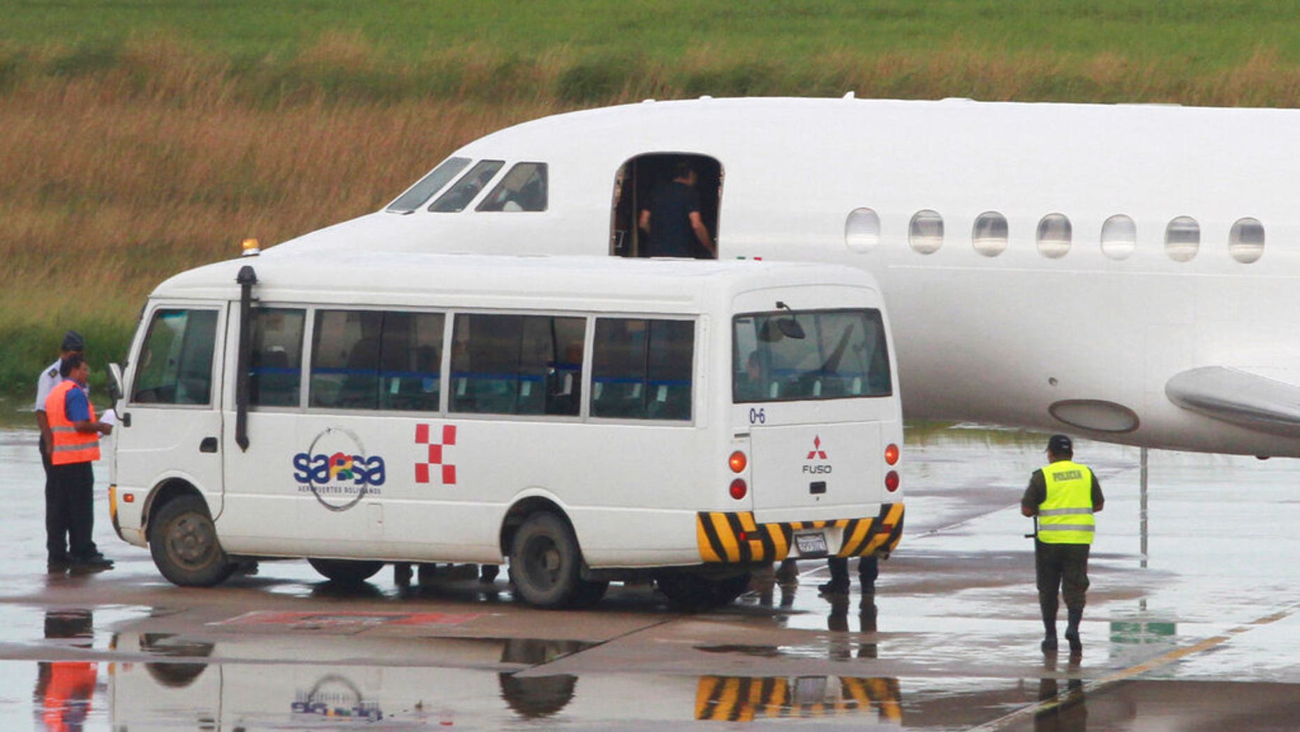 A man who appears to be Italian fugitive Cesare Battisti enters the cabin door of a plane before it takes off for Italy, where he will serve a life sentence, at the airport in Santa Cruz, Bolivia.