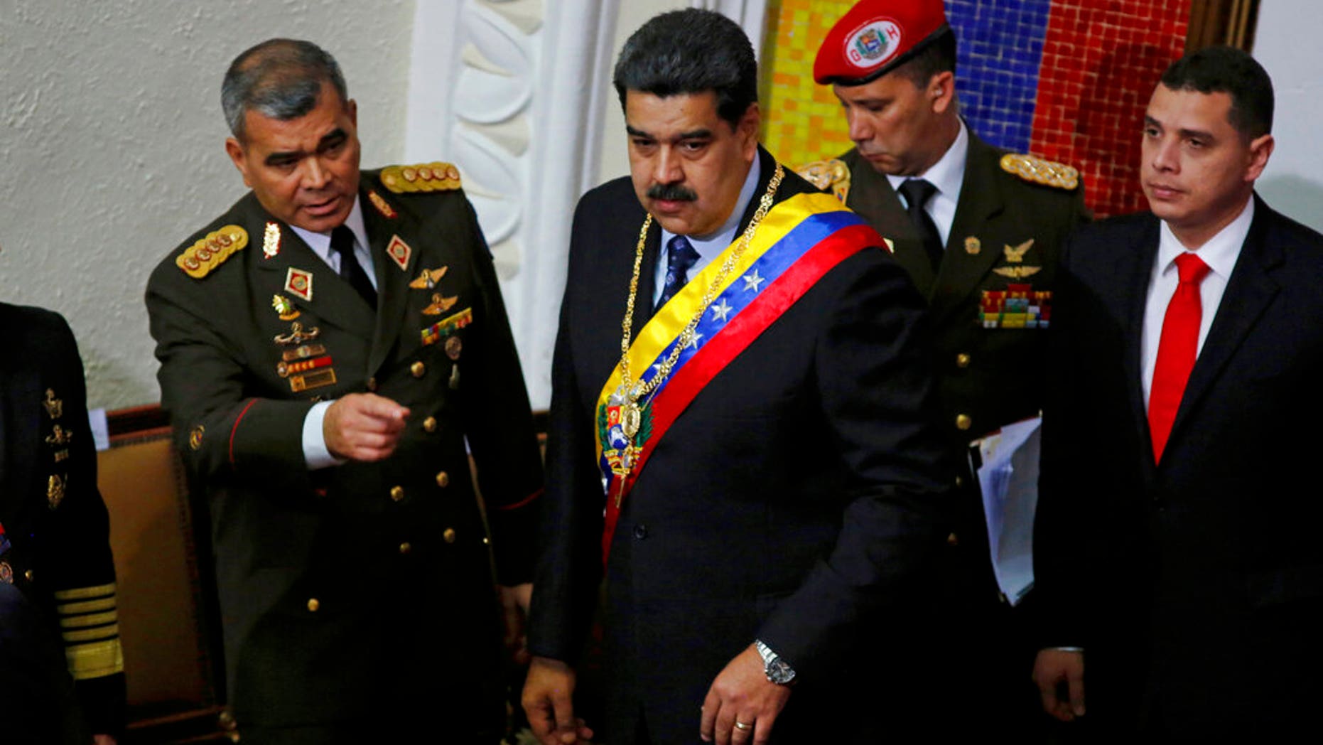 Venezuela's President Nicolas Maduro, center, stands with his Defense Minister Vladimir Padrino Lopez before giving his annual address to the nation to members of the Constitutional Assembly inside the National Assembly in Caracas, Venezuela, Monday, Jan. 14, 2019.