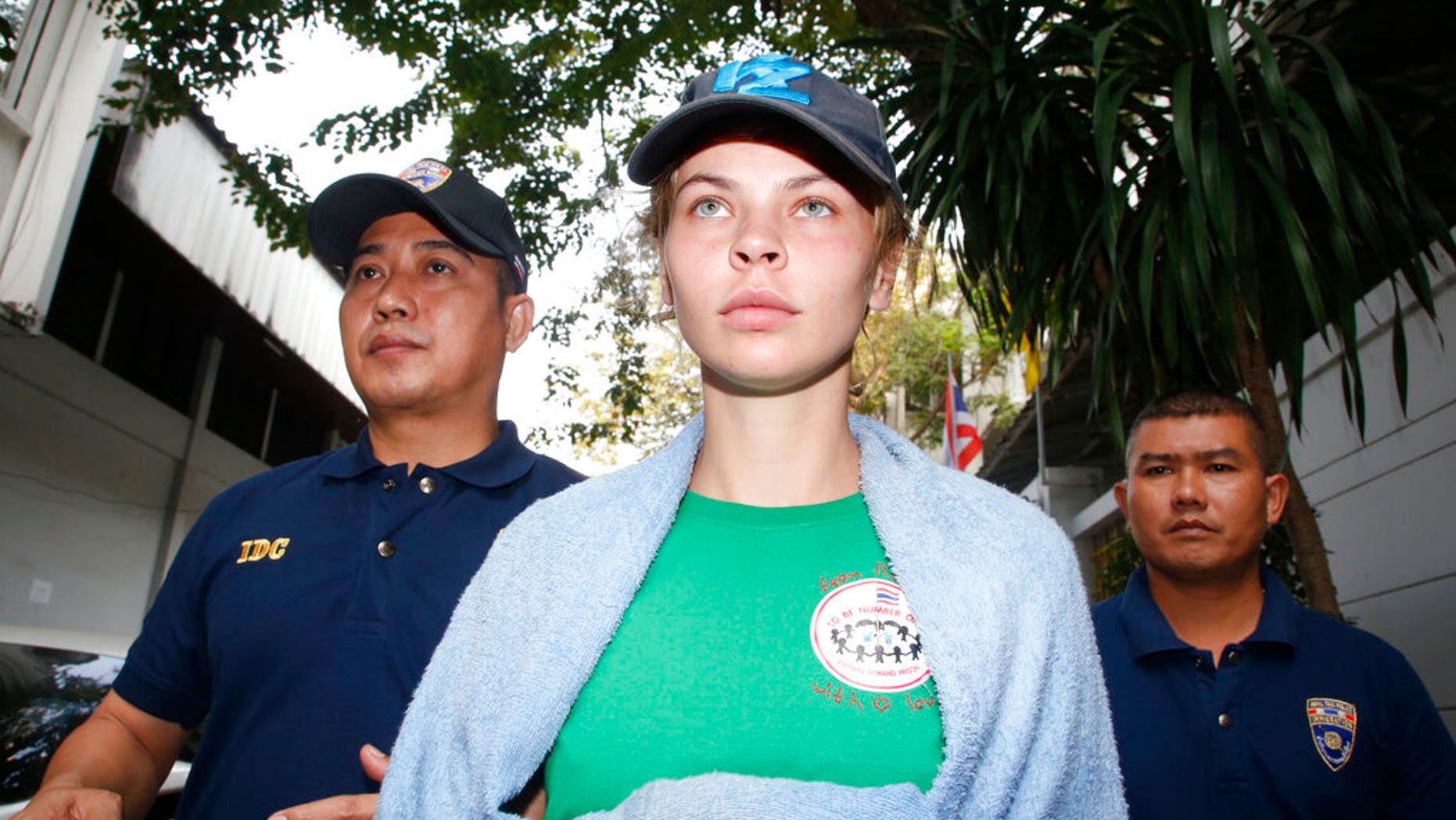 Thai Immigration police officers escort Belarusian model Anastasia Vashukevich, center, from the Immigration Detention Center toward a vehicle to take her to an airport for deportation, in Bangkok, Thailand. (Associated Press)