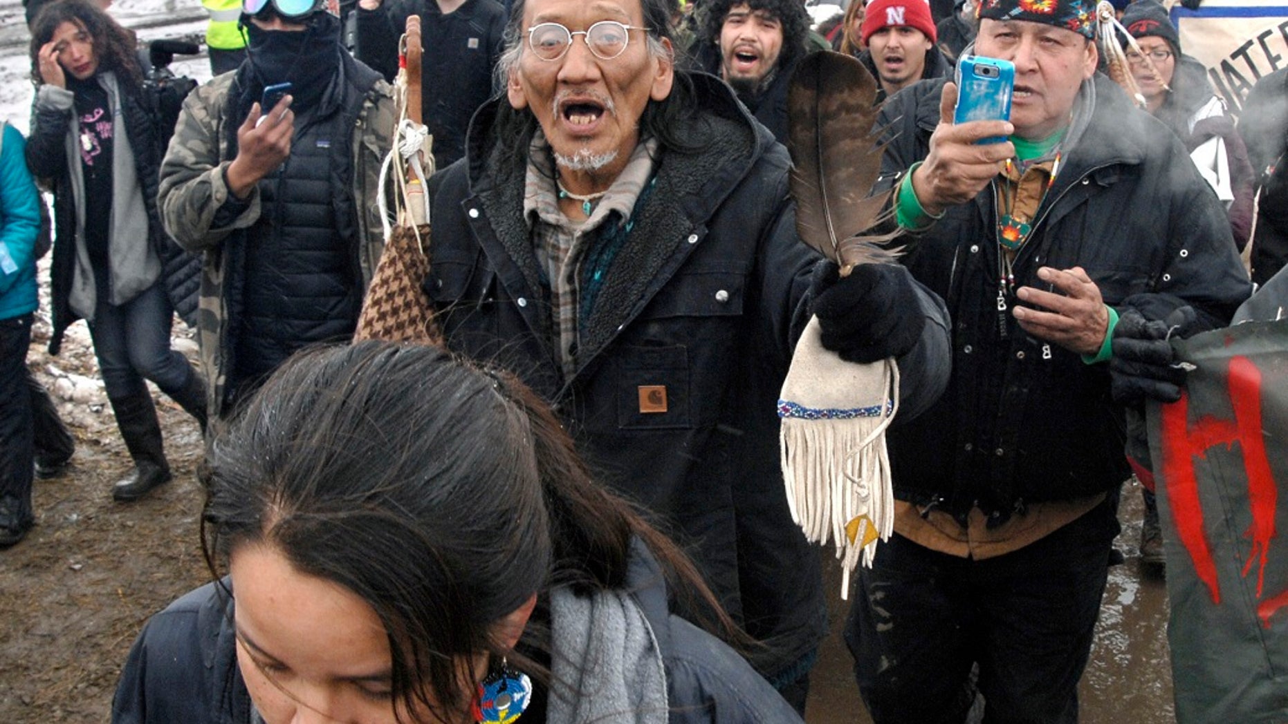 FILE - In this file photo from February 22, 2017, a large crowd marching across the Dakota Access pipeline, including Nathan Phillips, center with goggles, marching out of the Oceti Sakowin camp before the deadline ends up evacuating a large portion of the protesters of the camp near Cannon Ball, ND (Associated Press)