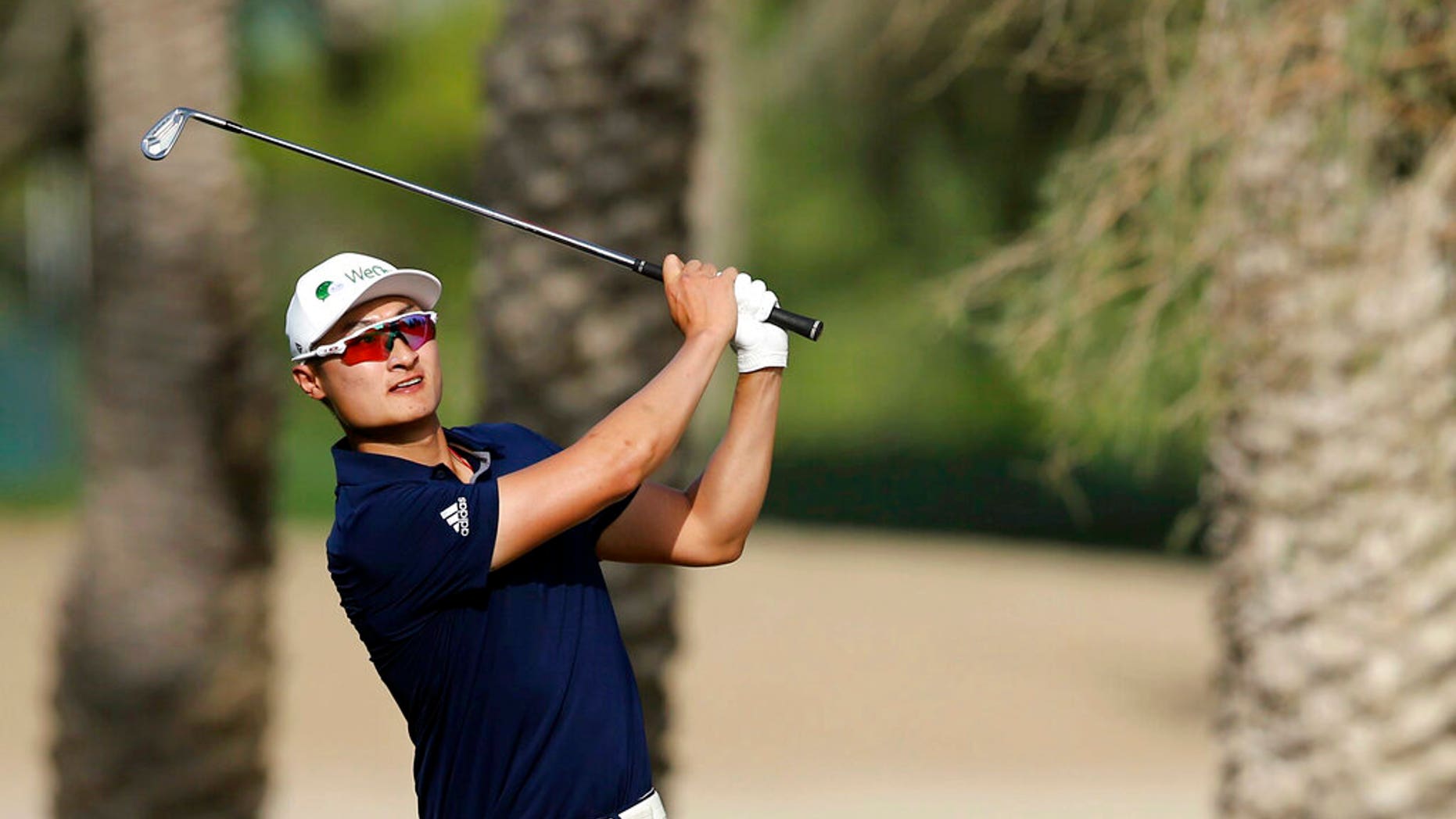Haotong Li follows his ball on the 14th hole during the third round of the Dubai Desert Classic Golf Tournament in Dubai, United Arab Emirates.