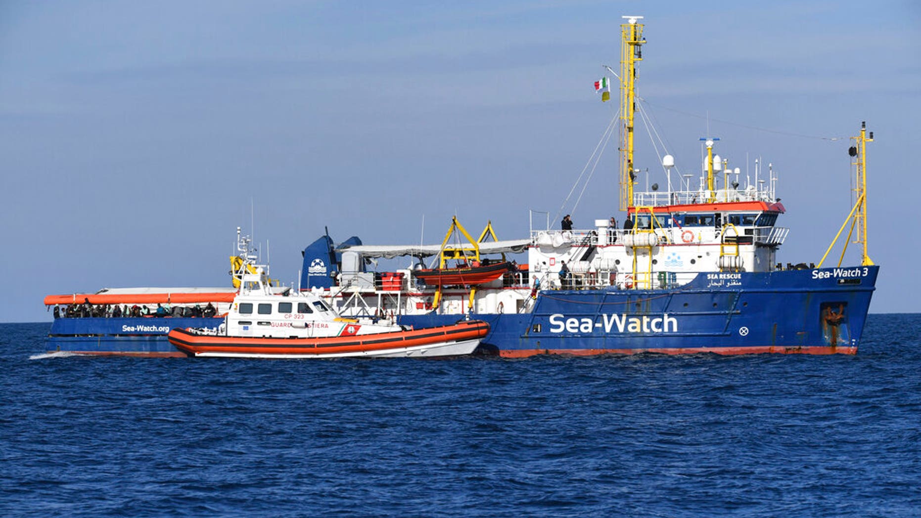 A Coast Guard boat approaches a German humanitarian group's rescue boat Sea Watch 3, to deliver food and blankets for the cold, off the coast of Syracuse, Italy, Sunday, Jan. 27, 2019. (AP Photo/Salvatore Cavalli)