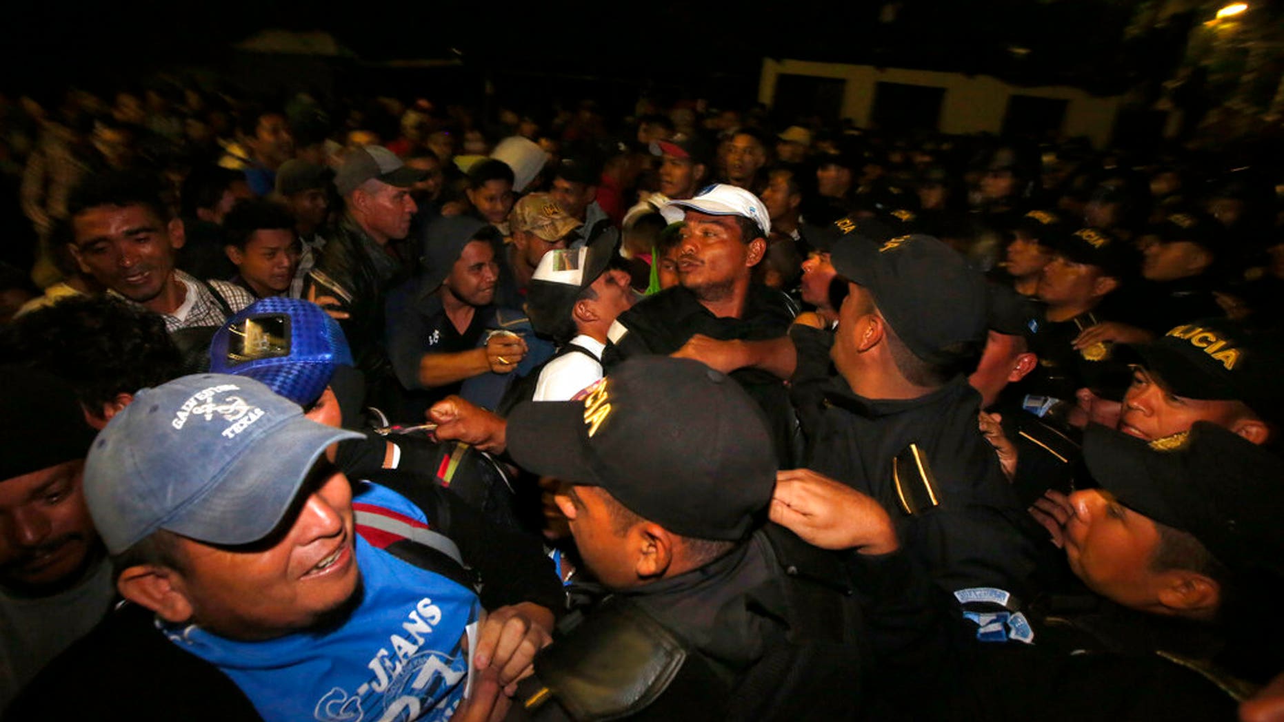 Honduran migrants wait to enter Guatemala at the border crossing in Agua Caliente, Tuesday, Jan. 15, 2019. The latest caravan of Honduran migrants hoping to reach the U.S. has crossed peacefully into Guatemala, under the watchful eyes of about 200 Guatemalan police and soldiers. (AP Photo/Moises Castillo)