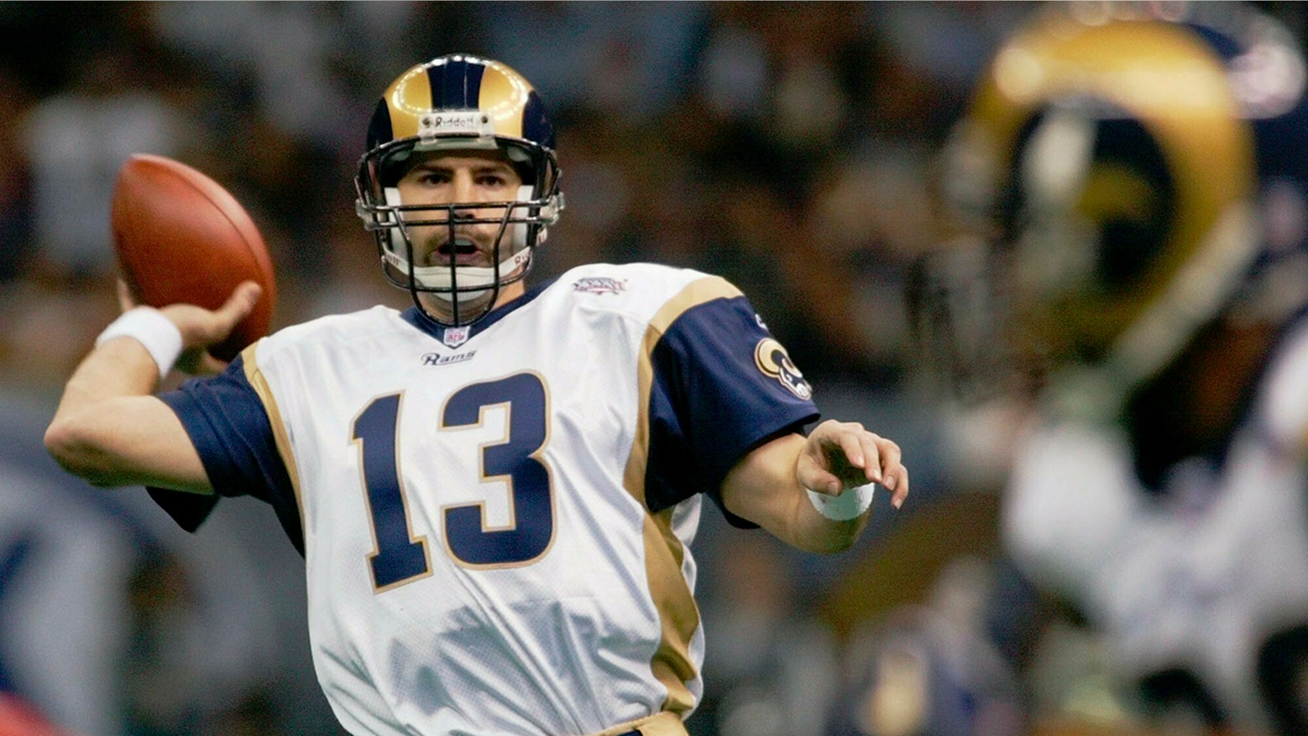 FILE - In this Feb. 3, 2002, file photo, St. Louis Rams quarterback Kurt Warner looks to pass to Marshall Faulk, right, in the first quarter against the New England Patriots in Super Bowl 36 in New Orleans.