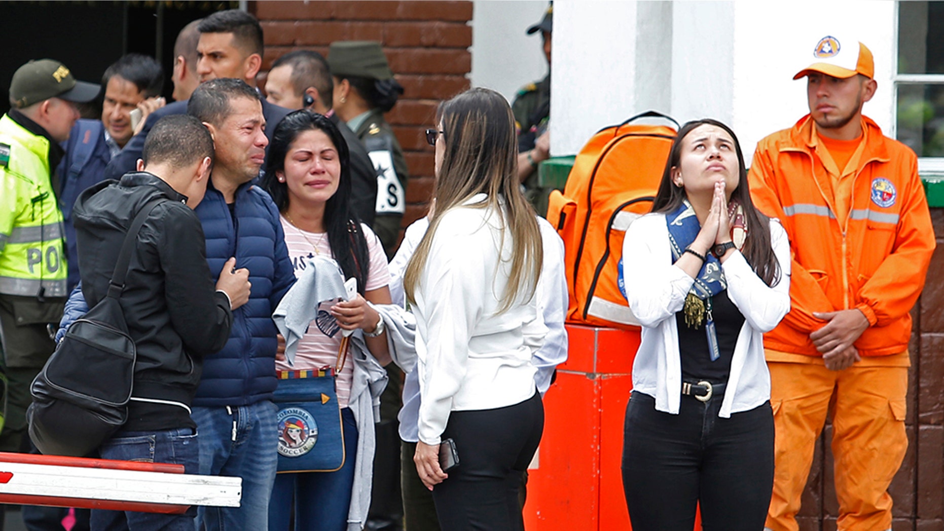 Family members of victims of a bombing gather outside the entrance to the General Santander police academy where the bombing took place in Bogota, Colombia, Thursday.