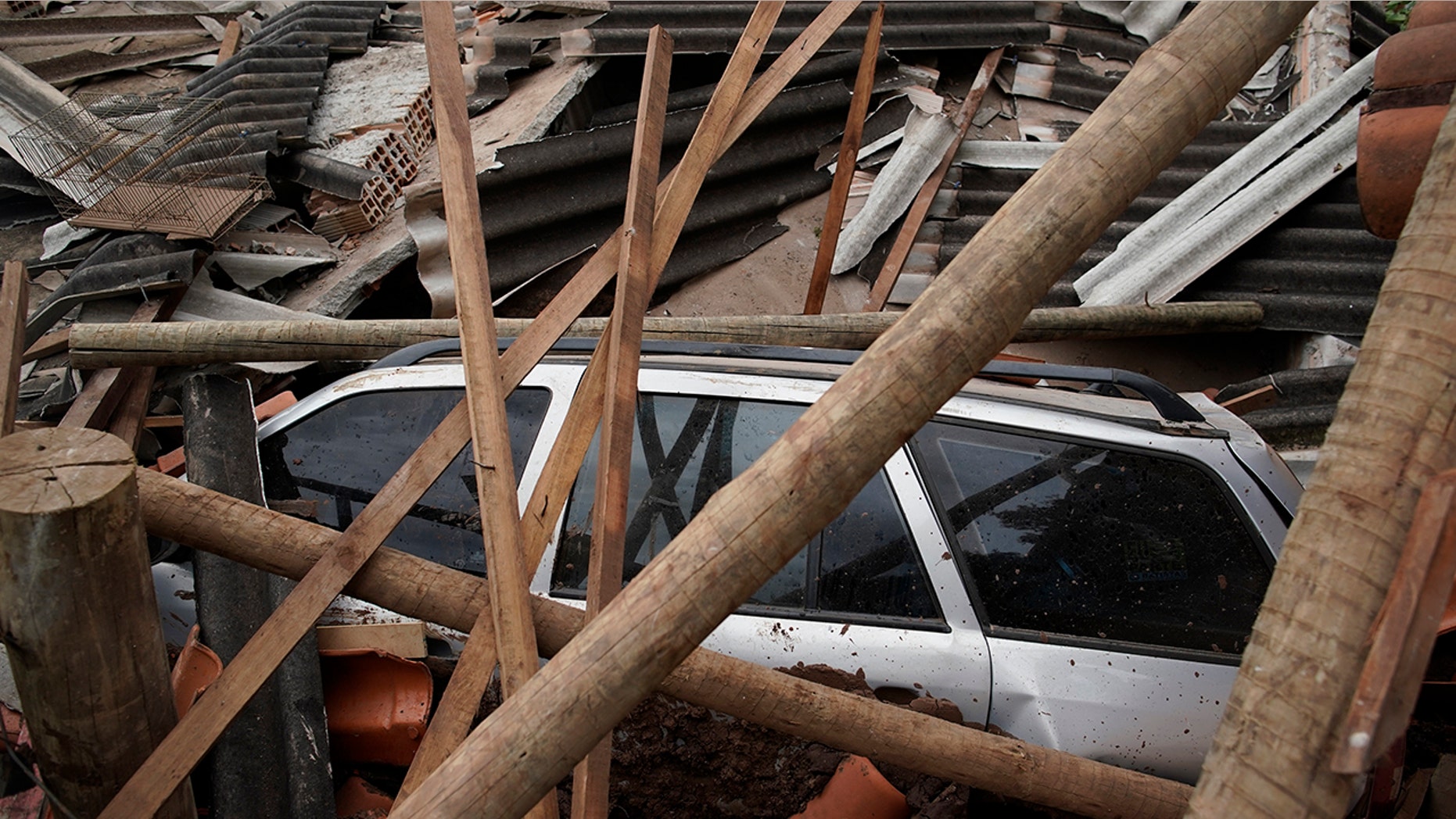 A car lies covered in debris after a dam collapse near Brumadinho, Brazil, Saturday, Jan. 26, 2019. (Associated Press)