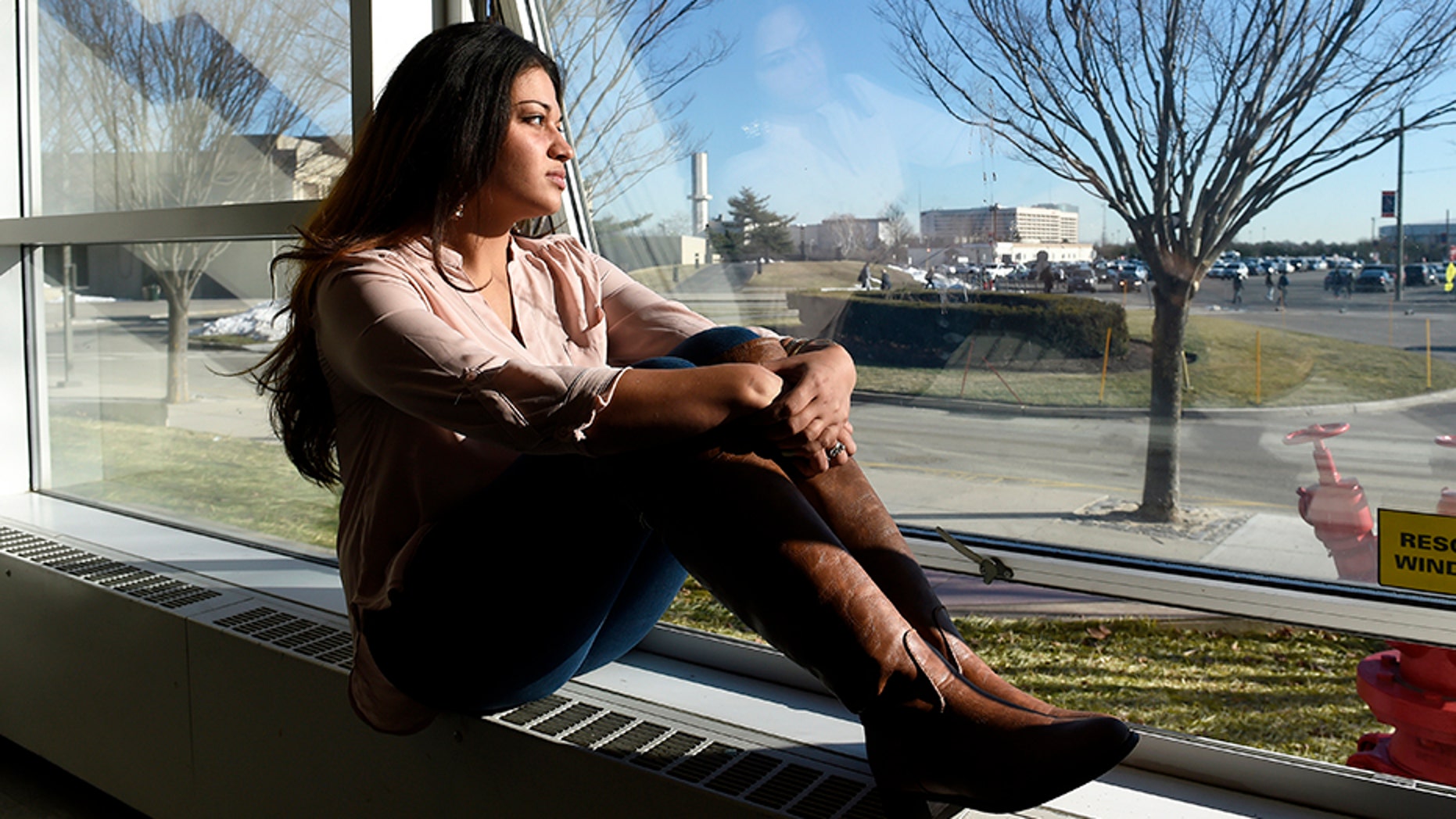 In this Feb. 2, 2016, file photo, Naila Amin, 26, looks out from a classroom window at Nassau Community College in Garden City, N.Y.