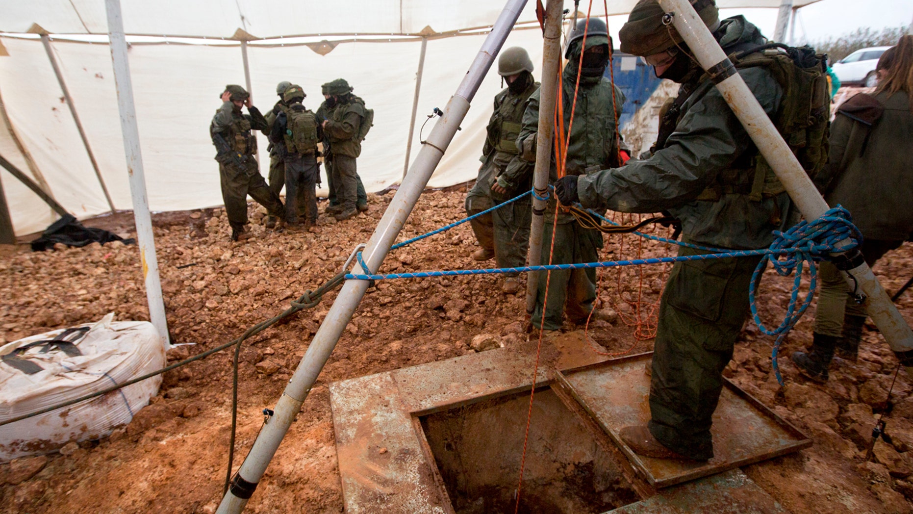 In this Wednesday, Dec. 19, 2018 file photo, Israeli soldiers stand around the opening of a hole that leads to a tunnel that the army says crosses from Lebanon to Israel, near Metula.
