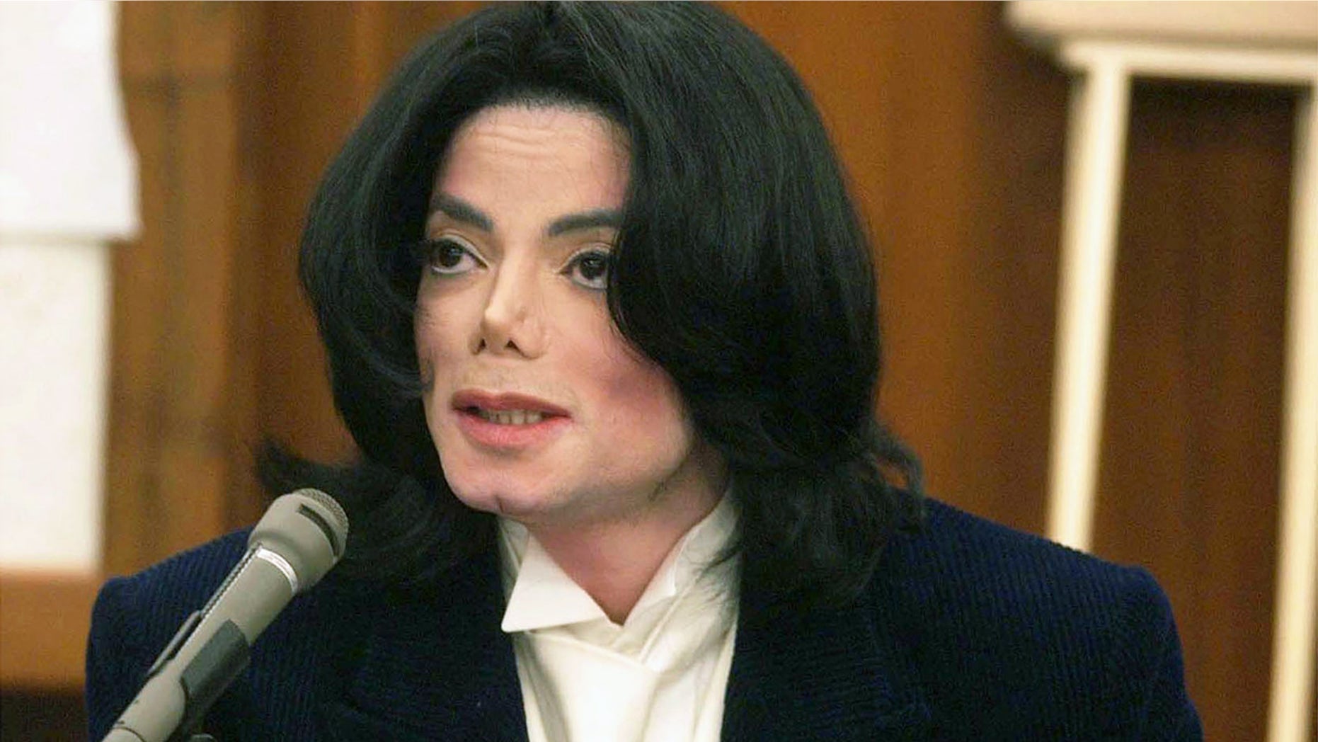 Michael Jackson speaks with photographers during a break in his testimony December 3, 2002 in Santa Maria, California. The late Jackson was being sued for $21 million for breach of contract over two millennium concerts. (Photo by Jim Ruymen - Pool/Getty Images)