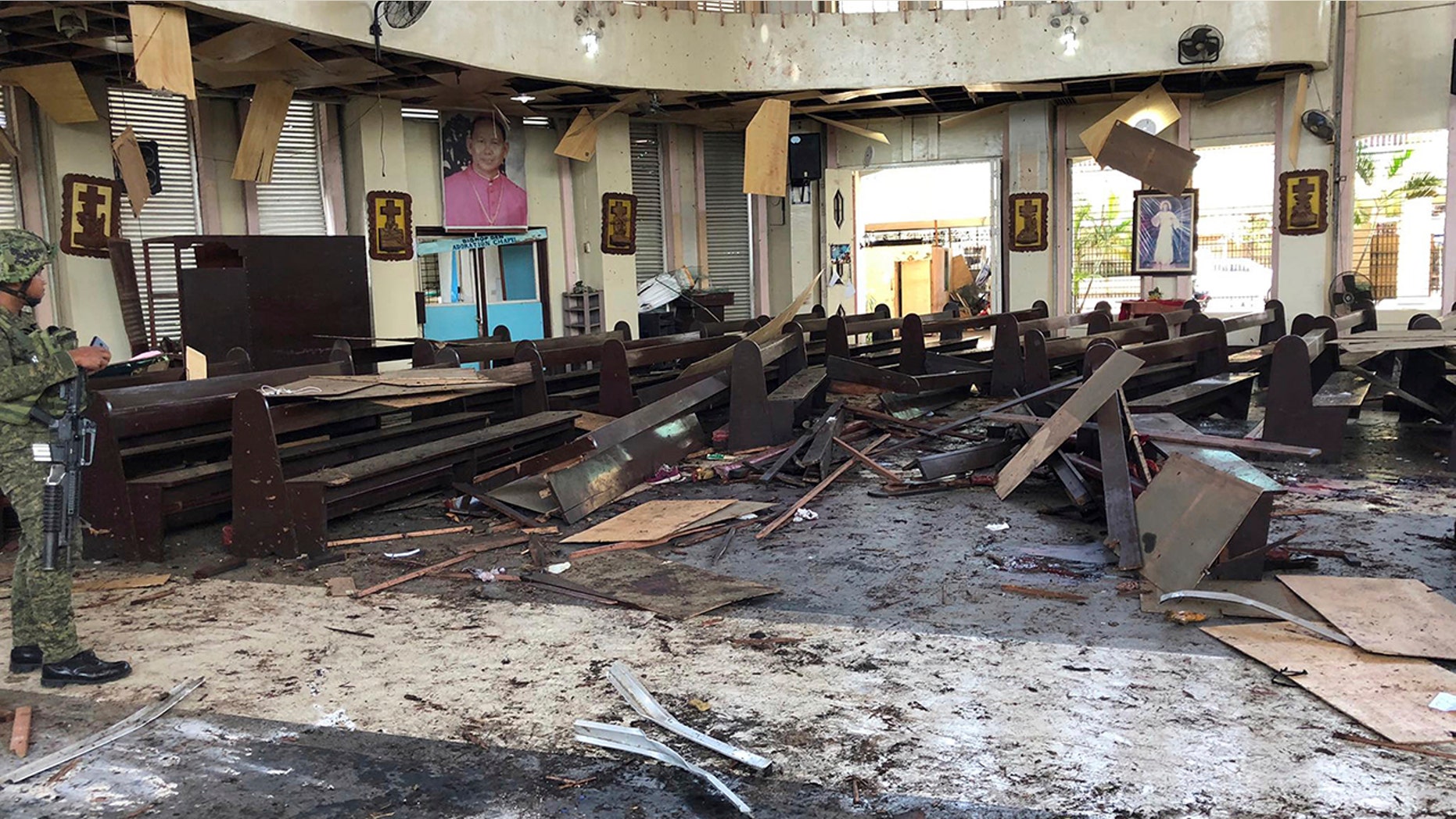 A soldier views the site inside a Roman Catholic cathedral in Jolo, the capital of Sulu province in the southern Philippines after two bombs exploded Sunday, Jan. 27, 2019. (WESMINCOM Armed Forces of the Philippines Via AP)