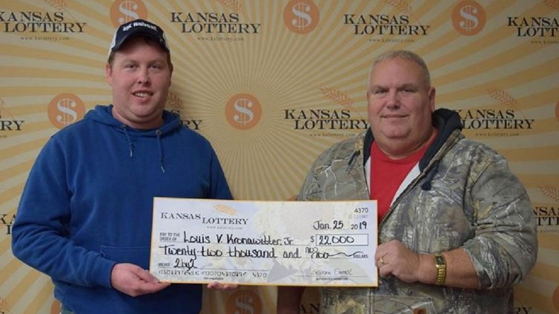 Kansas Lottery winner Louis V. Kronawitter Jr., right, and his son Austin Kronawitter pose with a $22,000 check. (Kansas Lottery)