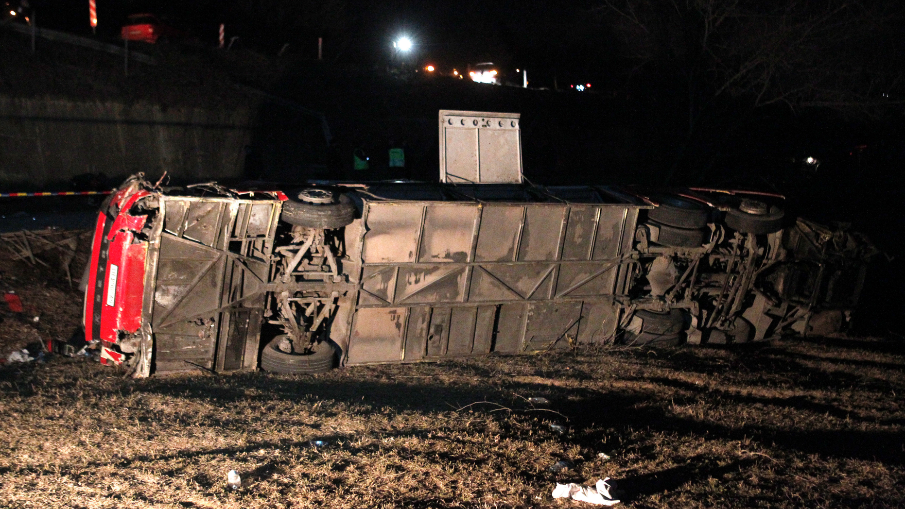A bus lays overturned at the crash site at village of Laskarci, west of Skopje, North Macedonia, Wednesday, Feb. 13, 2019. Macedonia's health minister says some have died and many are injured in the bus crash, carrying workers on a highway west of the capital, Skopje. (AP Photo/Boris Grdanoski)