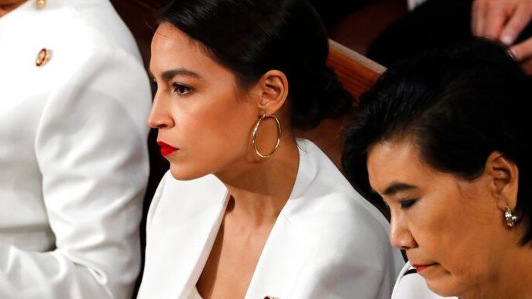 Rep. Alexandria Ocasio-Cortez, D-N.Y., center, listens as President Donald Trump delivers his State of the Union address to a joint session of Congress on Capitol Hill in Washington, Tuesday, Feb. 5, 2019. (AP Photo/J. Scott Applewhite)