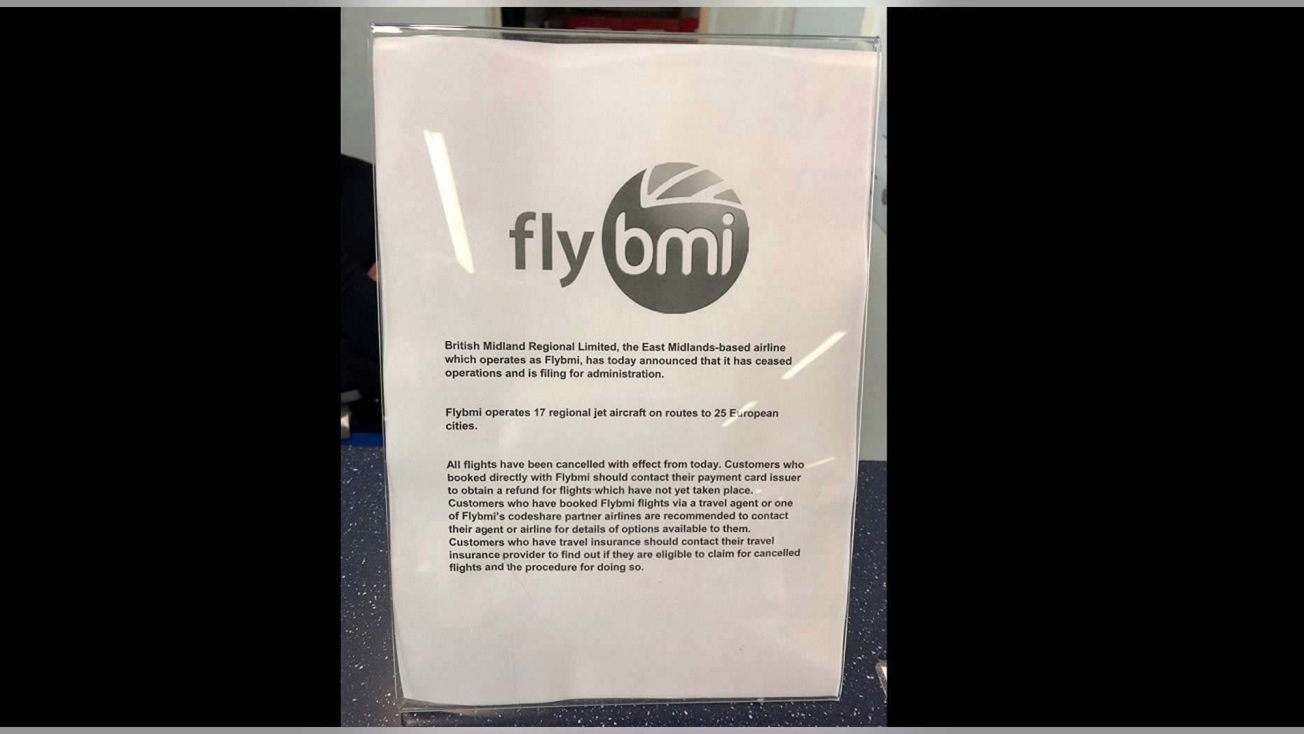 A notice informing passengers that Flybmi flights have been cancelled following the collapse of the airline, at Bristol Airport in Bristol, England, Sunday, Feb. 17, 2019. (PA via AP)