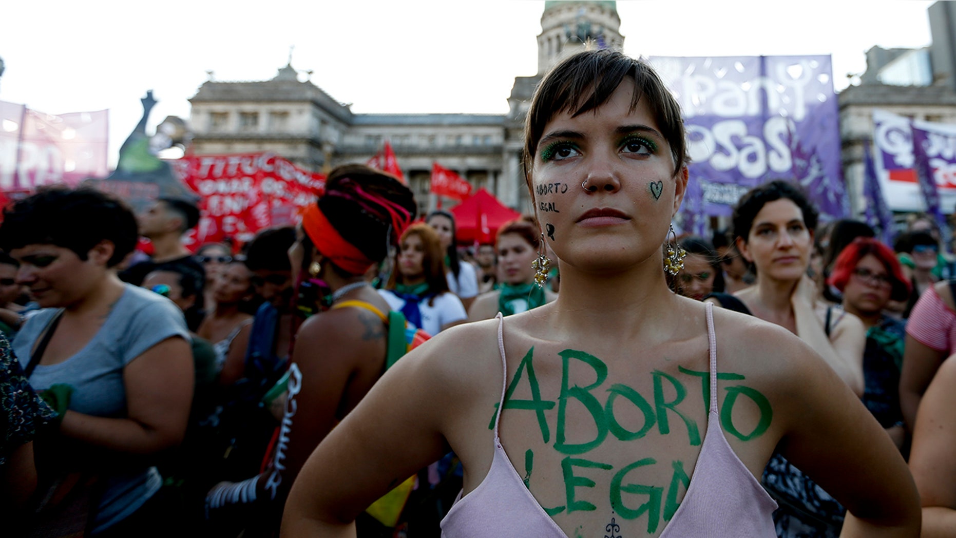 A woman covered by the Spanish words "Legal abortion" attends a pro-choice rally in favor of decriminalizing abortion outside Congress in Buenos Aires, Argentina, Tuesday, Feb. 19.