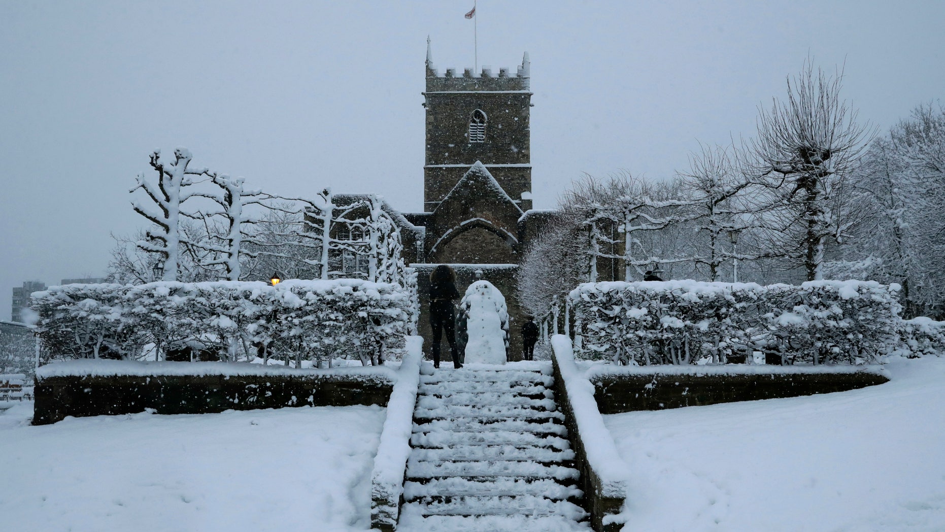 FILE - In this file photo dated Friday, Feb. 1, 2019, snow falls over St Peter's Church in Bristol, southwest England. The Church of England's governing Synod on Friday Feb. 22, 2019, lifted a 400-year-old rule requiring all churches to hold services every Sunday, acknowledging the reality of shrinking congregations and overworked priests. (AP Photo/Matt Dunham, FILE)