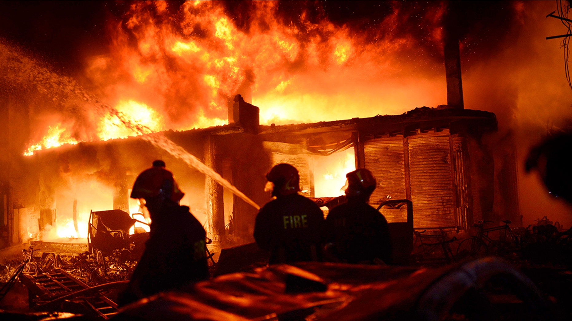 In this Wednesday, Feb. 20, 2019, photo, firefighters try to douse a fire in Dhaka, Bangladesh. A devastating fire raced through at least five buildings in an old part of Bangladesh's capital and killed scores of people. (AP Photo)
