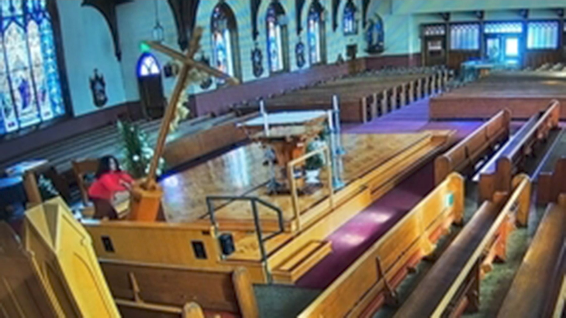 Image from surveillance footage that police say shows Jackeline Chavira, 23, knokcing over a 15 ft. crucifix at St. Patrick's Church in Watsonville, Calif.