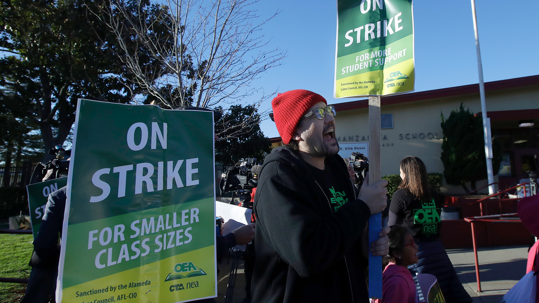 Garrick Ruiz, union member with United Teachers of Los Angeles, center, yells while teachers and supporters march outside of Manzanita Community School in Oakland, Calif., Thursday, Feb. 21, 2019. Teachers in Oakland went on strike Thursday in the country's latest walkout by educators over classroom conditions and pay. (AP Photo/Jeff Chiu)