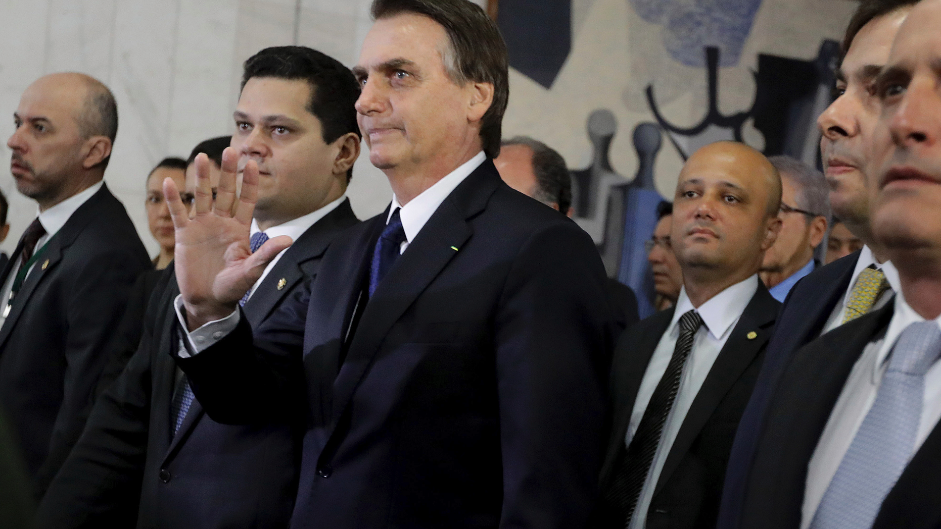 Brazil's President Jair Bolsonaro, center, arrives at the National Congress to deliver a proposal to overhaul Brazil's pension system, in Brasilia, Brazil, Wednesday, Feb. 20, 2019. Lawmakers received this week an anti-crime bill and a proposal to overhaul Brazil's pension system, the government's flagship reform. (AP Photo/Lucio Tavora)